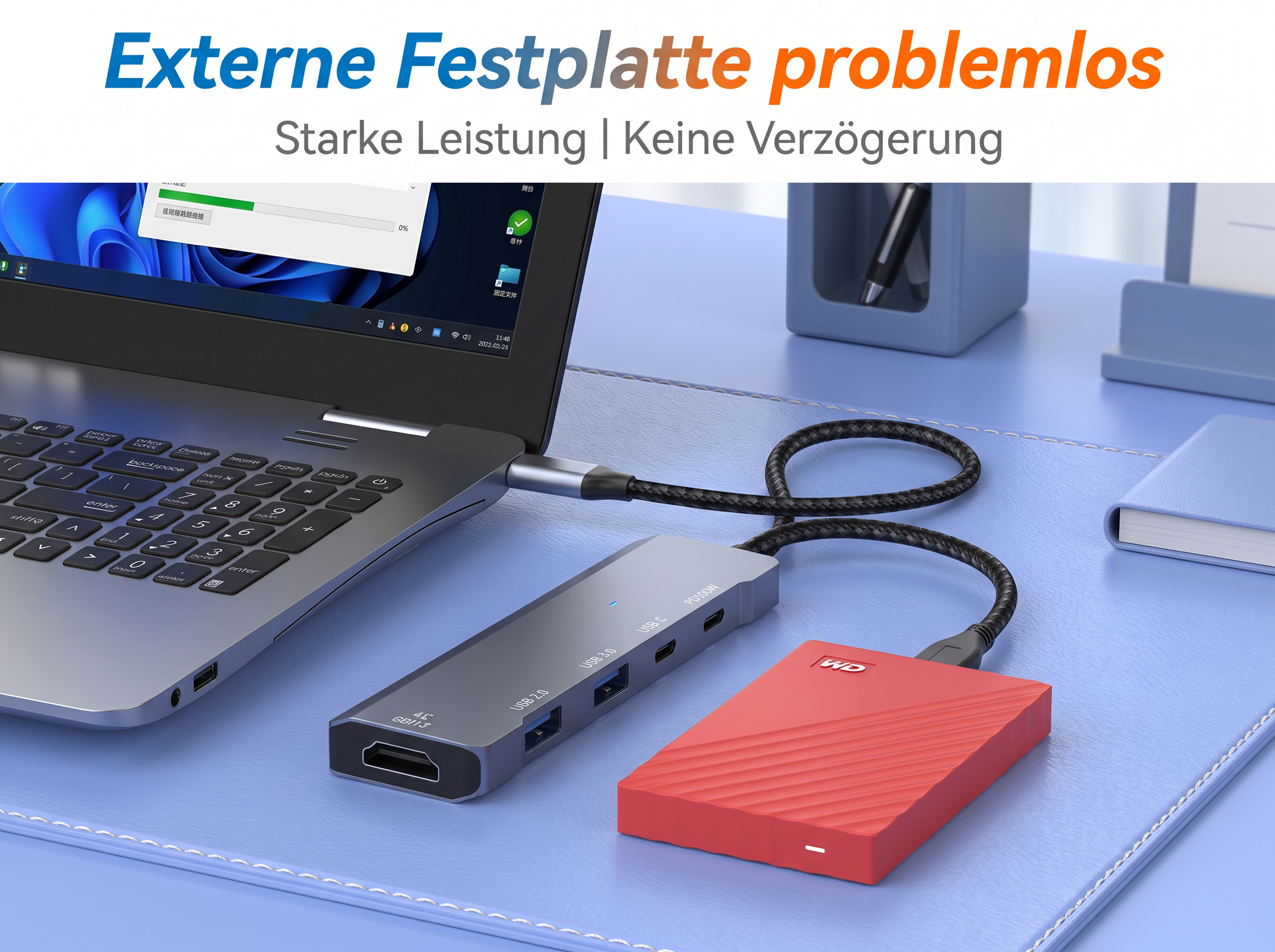Laptop auf blauem Schreibtisch mit grauem USB-C-Hub, geflochtenem Kabel und roter externer Festplatte.