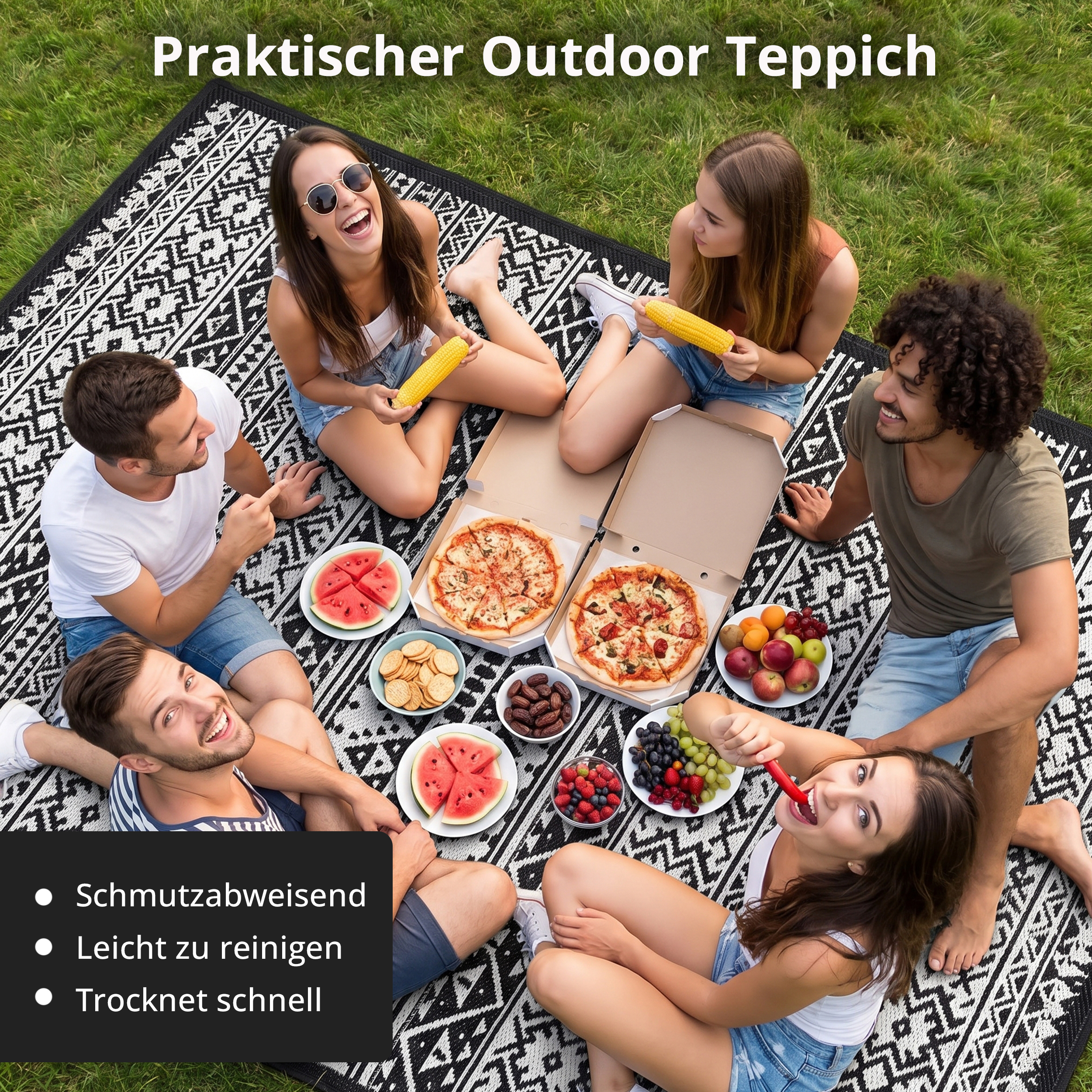 Fünf Freunde haben ein Picknick mit Pizza, Obst und Maiskolben auf einem schwarz-weißen Teppich im Gras.