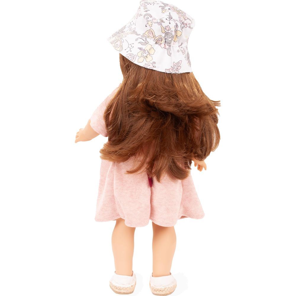 Vista posteriore di una bambola con lunghi capelli castani, cappello fantasia, abito rosa e scarpe bianche su sfondo bianco.