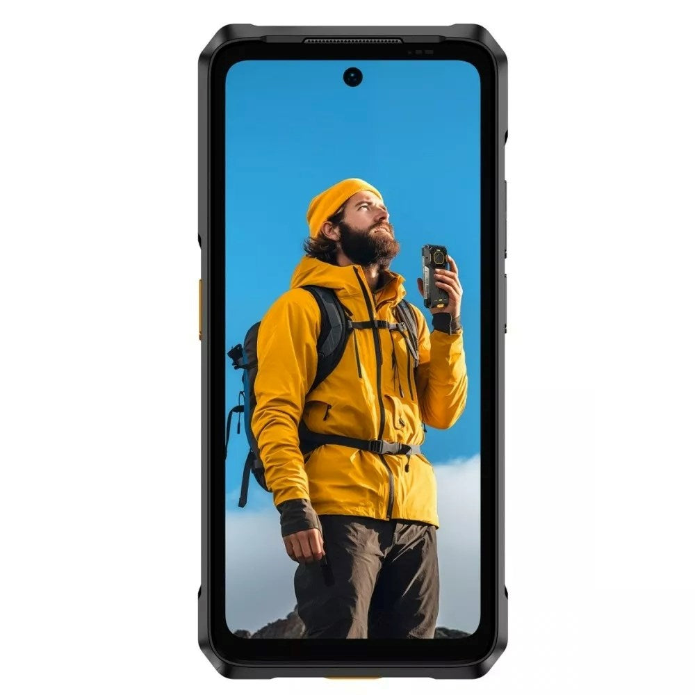 Wytrzymały smartfon przedstawia brodatego wędrowca w żółtej kurtce i czapce trzymającego urządzenie pod błękitnym niebem.
