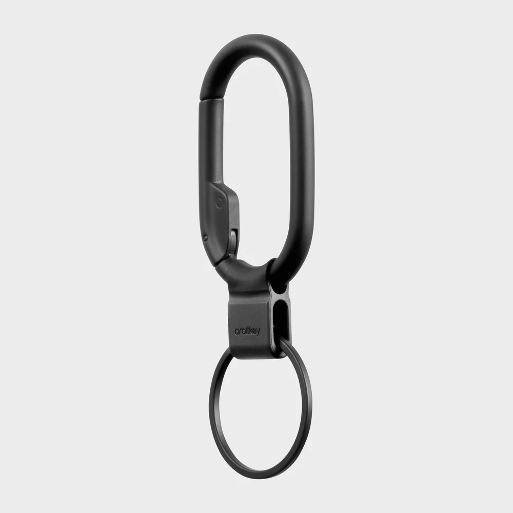 Czarny karabińczyki Orbitkey z kółkiem na klucze na szarym tle.