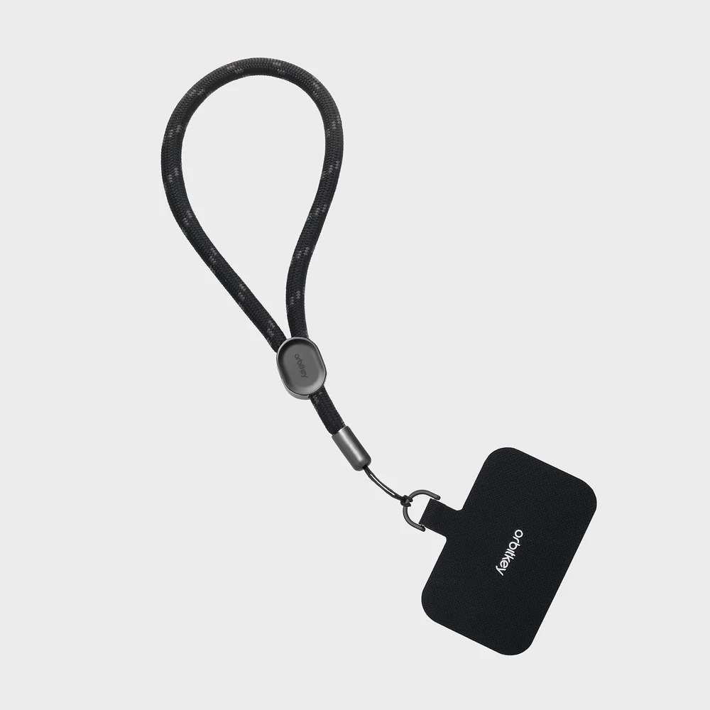 Czarny pasek na rękę Orbitkey z pętlą i zaczepem na jasnoszarym tle.