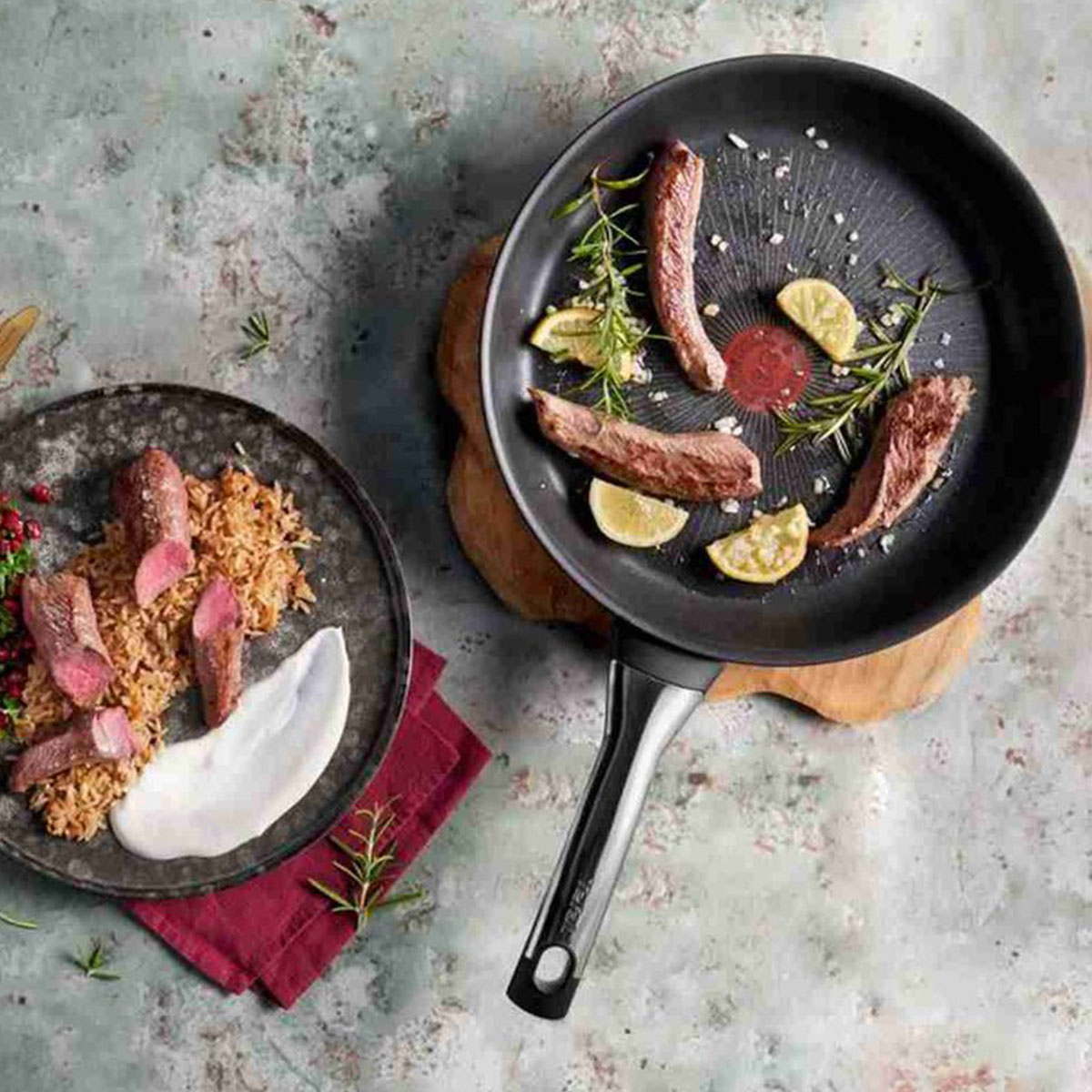 Sartén con carne, limones y hierbas; plato al lado con carne, arroz y salsa.