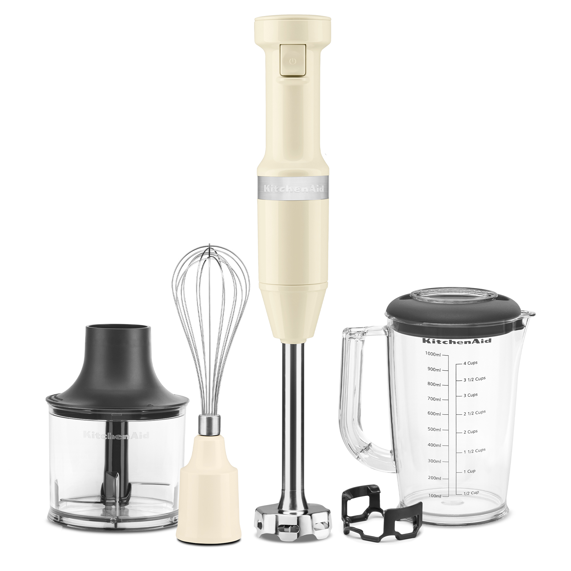 Kremowy blender ręczny KitchenAid z akcesoriami, takimi jak trzepaczka, dzbanek i rozdrabniacz, na białym tle.