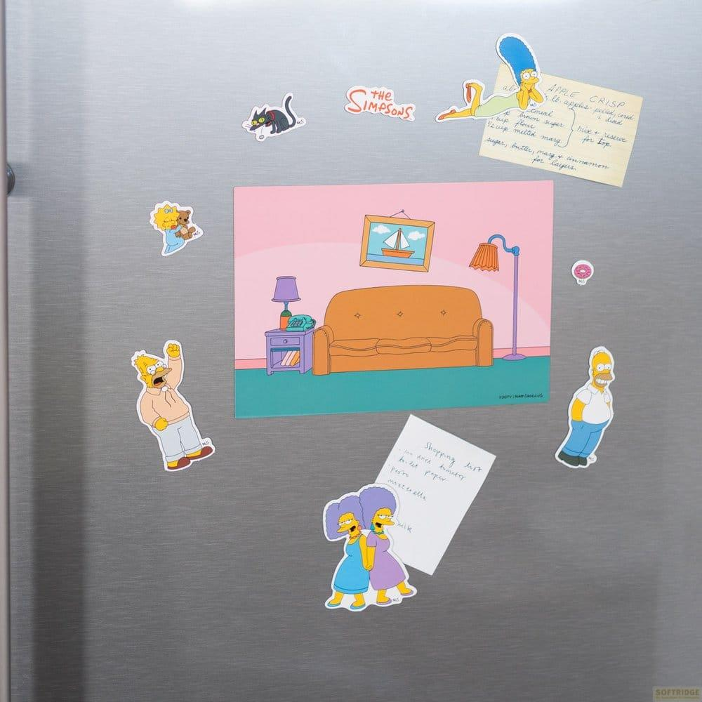 Eine Edelstahl-Kühlschranktür mit Simpsons-Magneten, Notizen und einem zentralen Wohnzimmer-Motiv.
