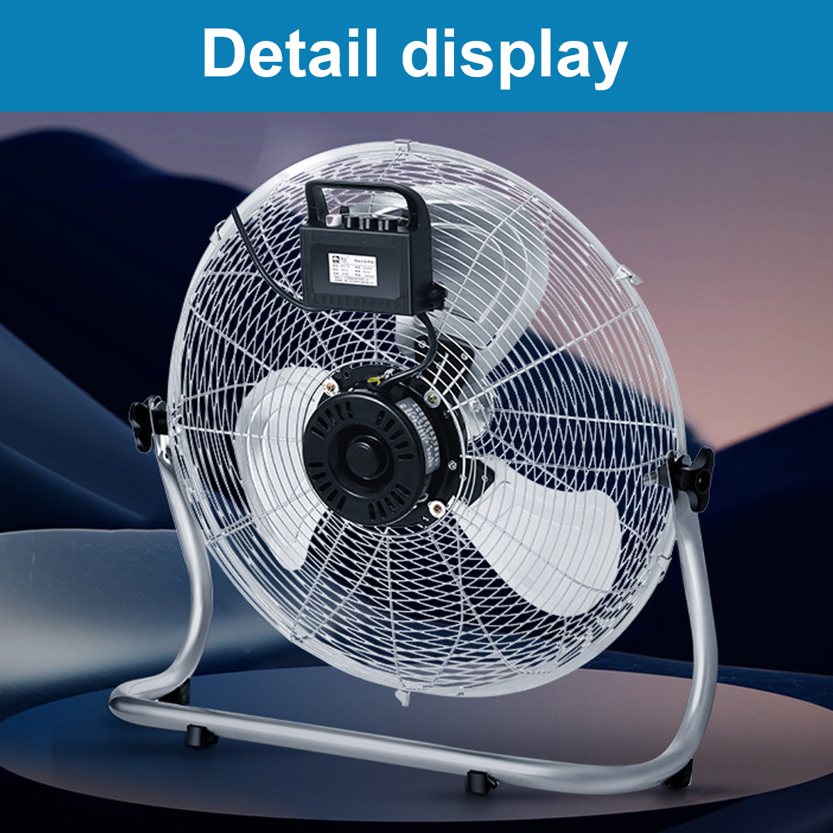 Silberner Tischventilator mit Schutzgitter und schwarzem Motor auf dunklem Hintergrund.