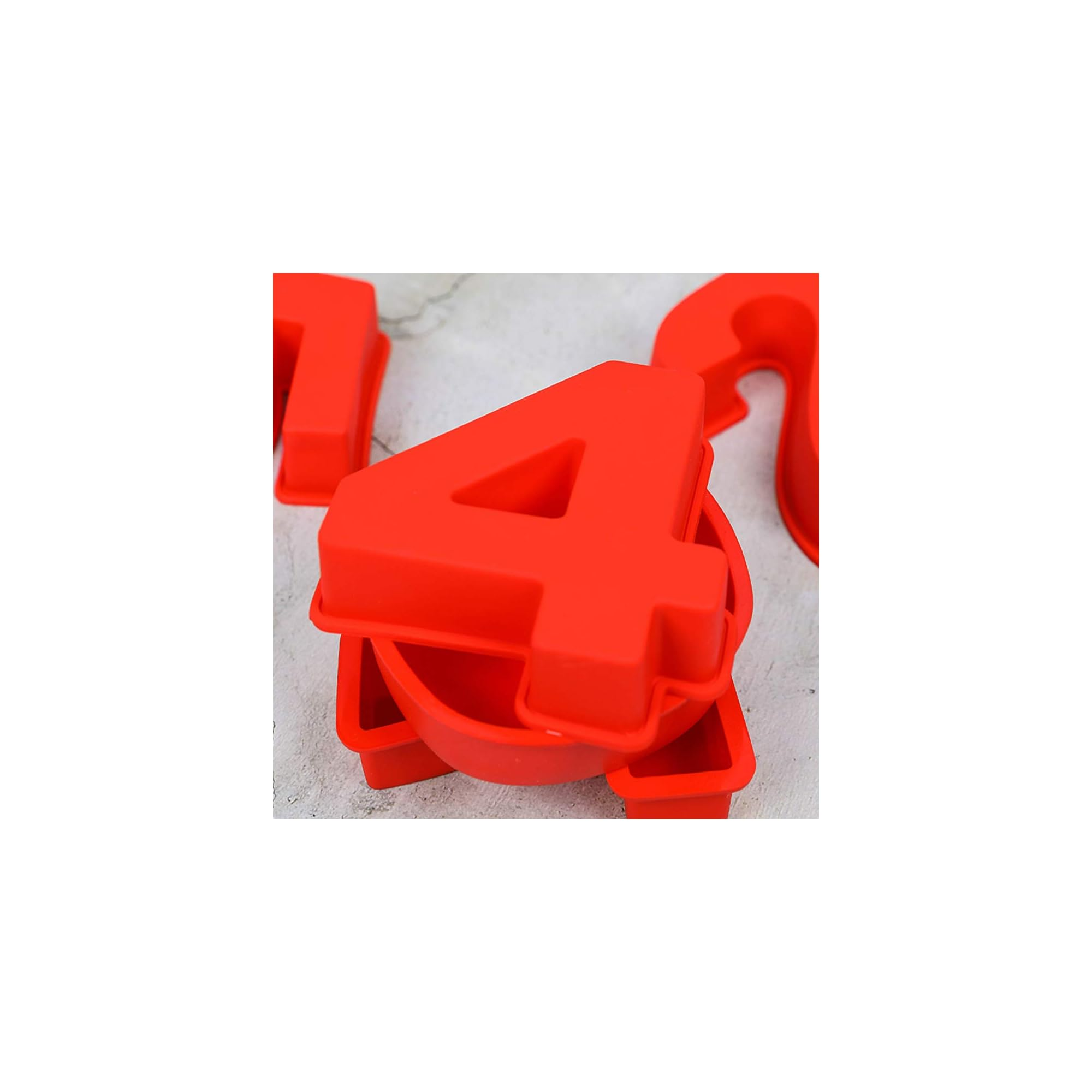 Rote Silikon-Zahlenkuchenform 4 auf hellem Betonhintergrund mit anderen verschwommenen roten Zahlenformen.