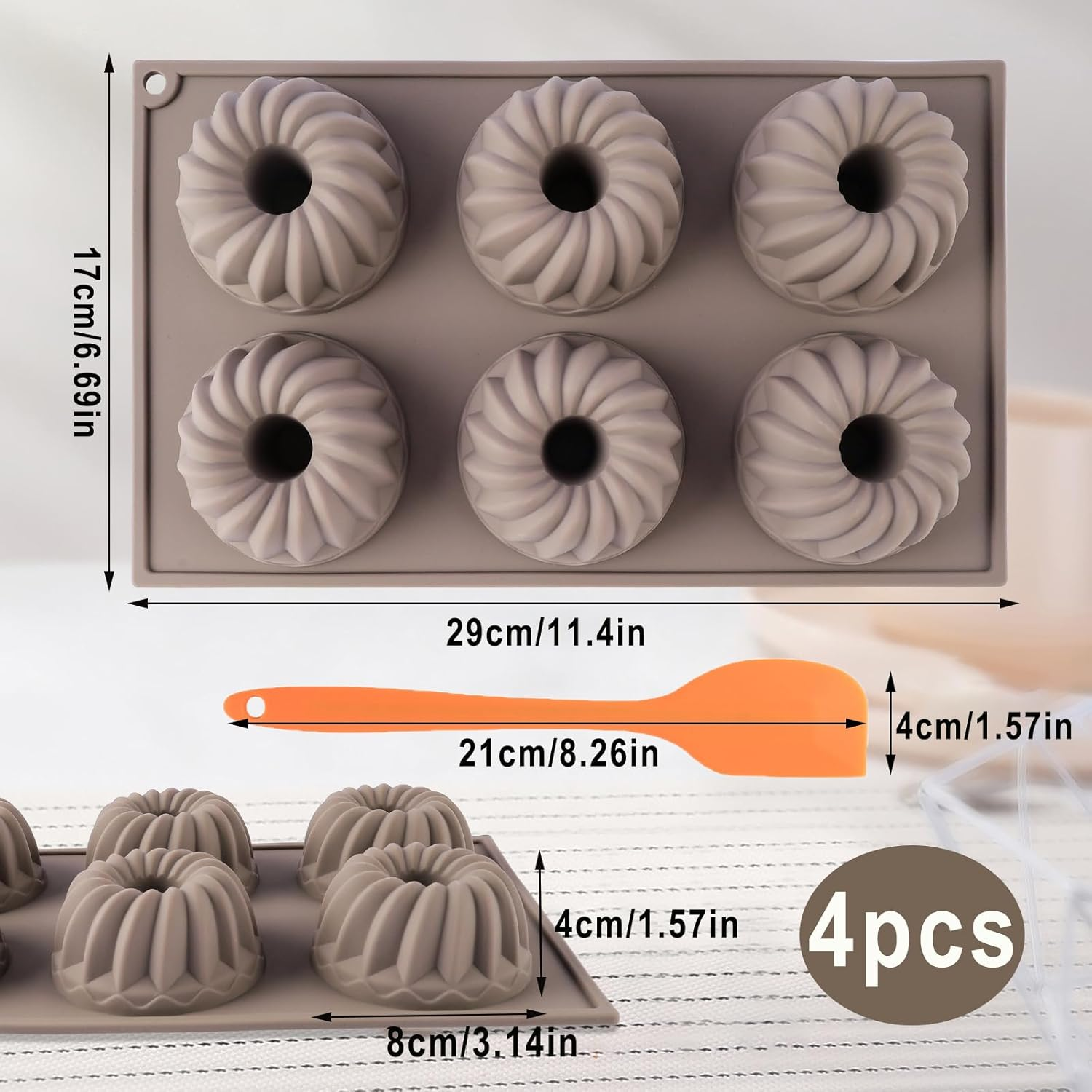 Graue Silikonbackform für sechs kleine Gugelhupfe mit orangefarbenem Spatel und Maßangaben.