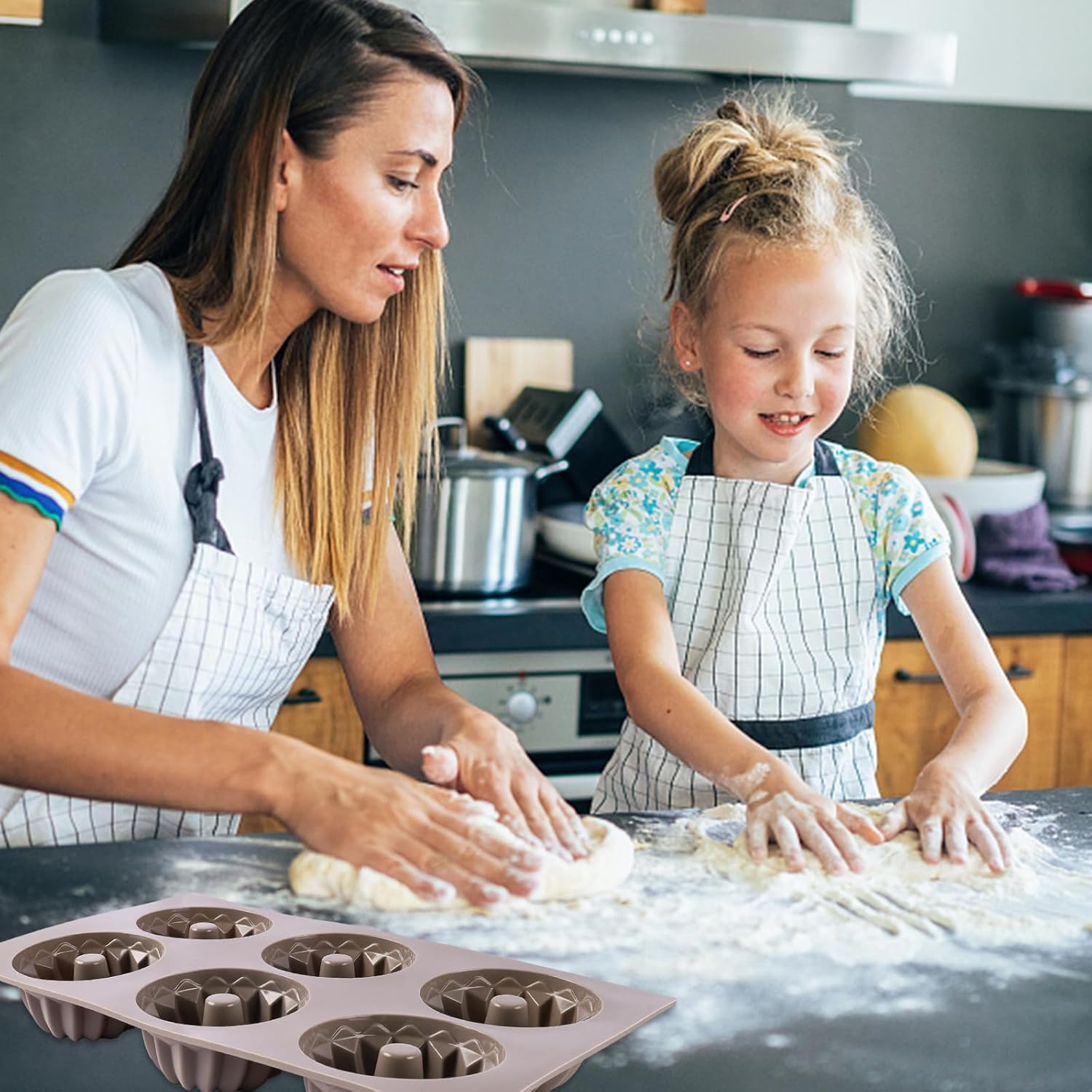 Mutter und Tochter kneten Teig in einer Küche, im Vordergrund ist eine Silikonbackform.