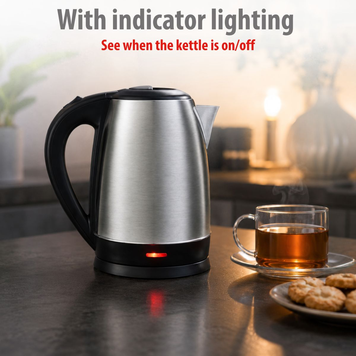 A silver kettle with a red indicator light on a table next to tea and cookies.