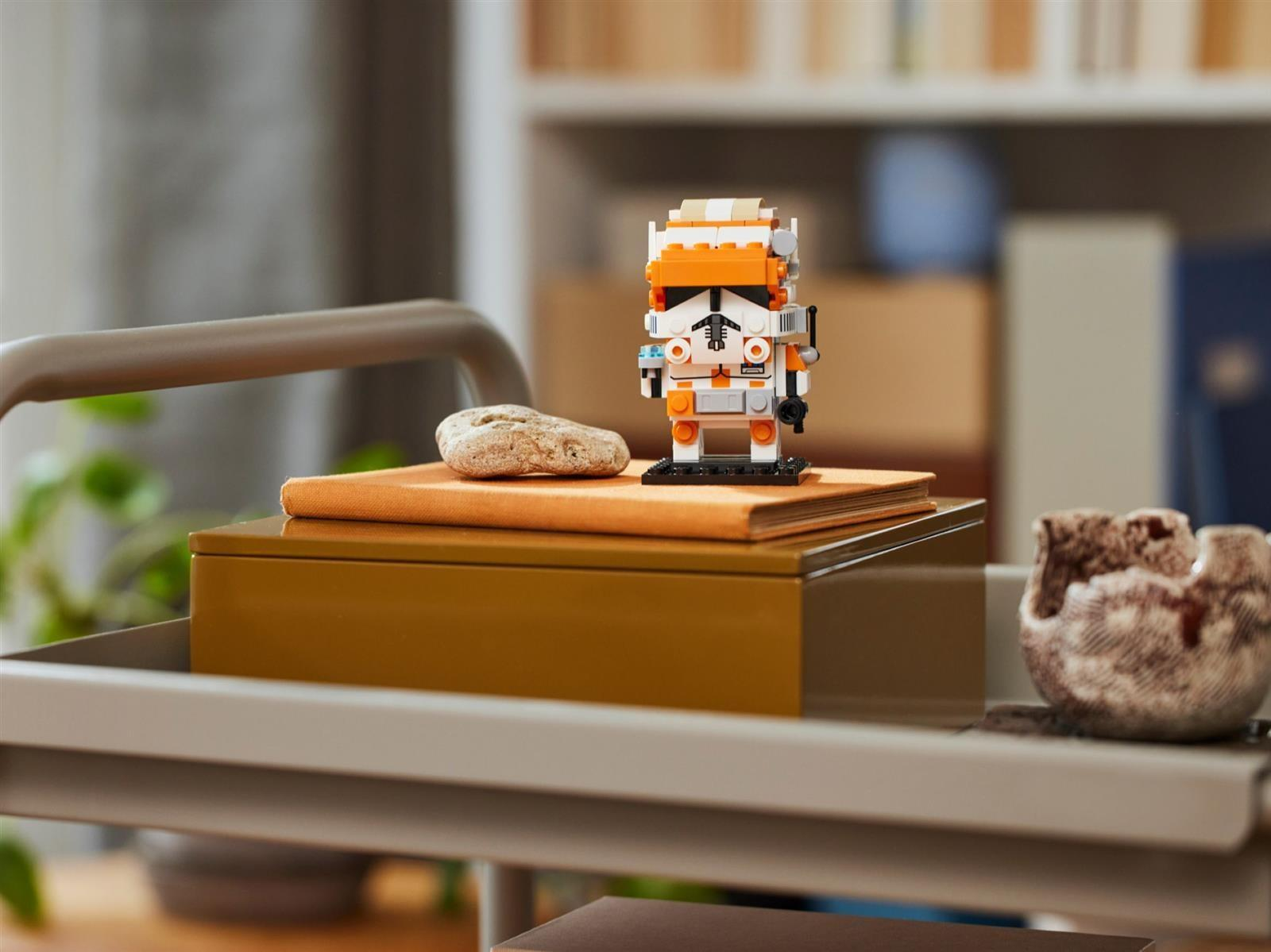Eine Lego-Figur eines Klonsoldaten steht auf einem Buch auf einer Box.