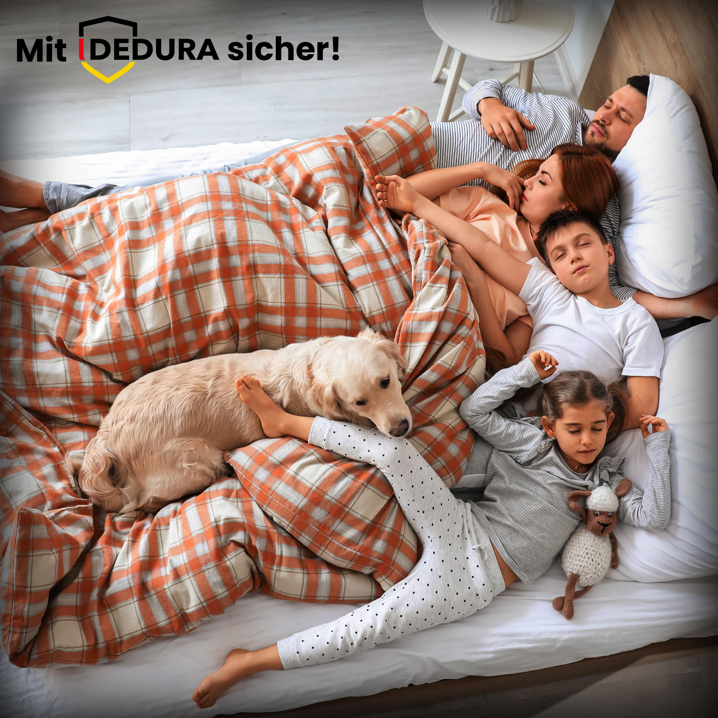 Eine Familie mit zwei Kindern und ihrem Hund schläft gemütlich in einem Bett.