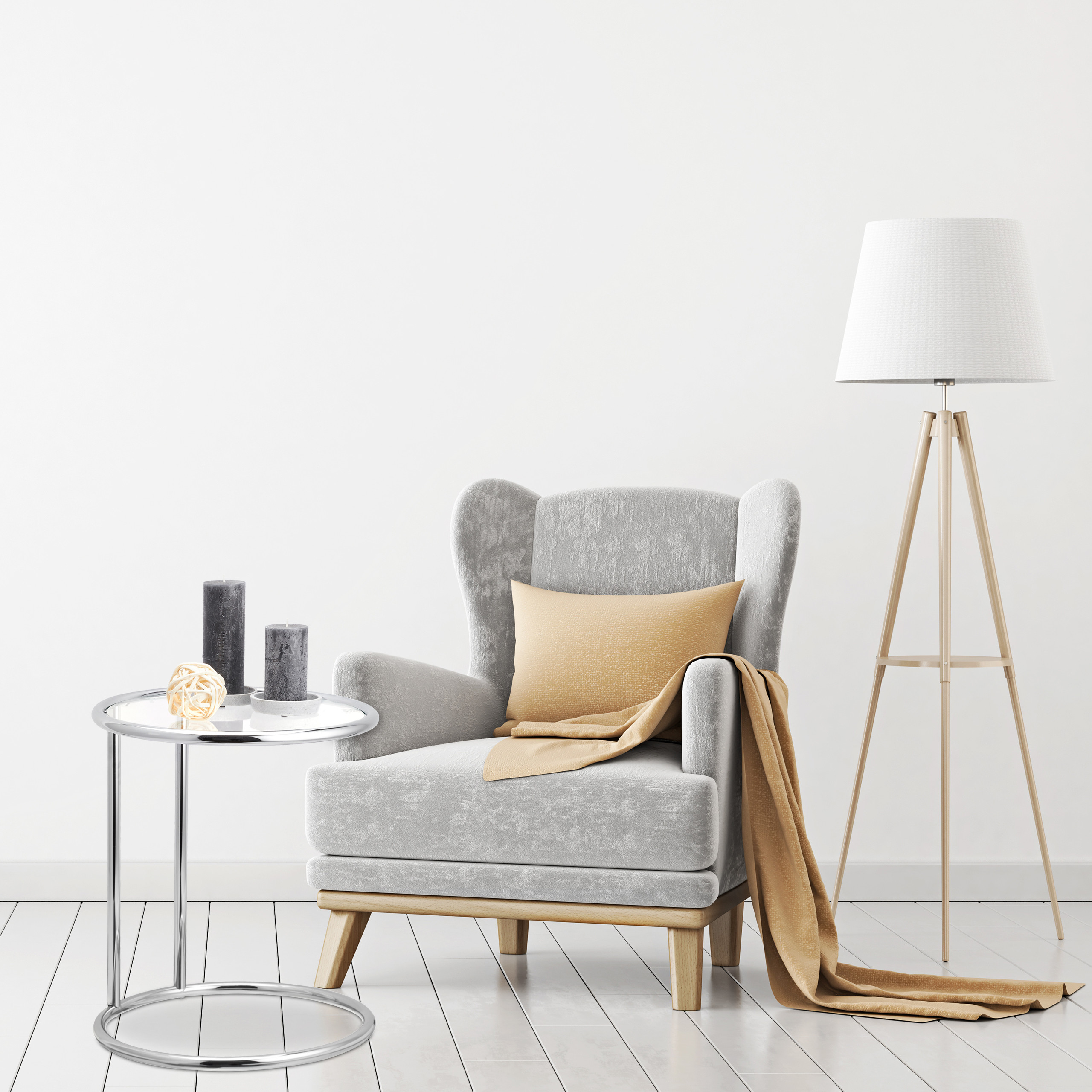 Ein grauer Sessel mit Kissen, Decke, kleinem Tisch mit Kerzen und einer Stehlampe vor weißer Wand.
