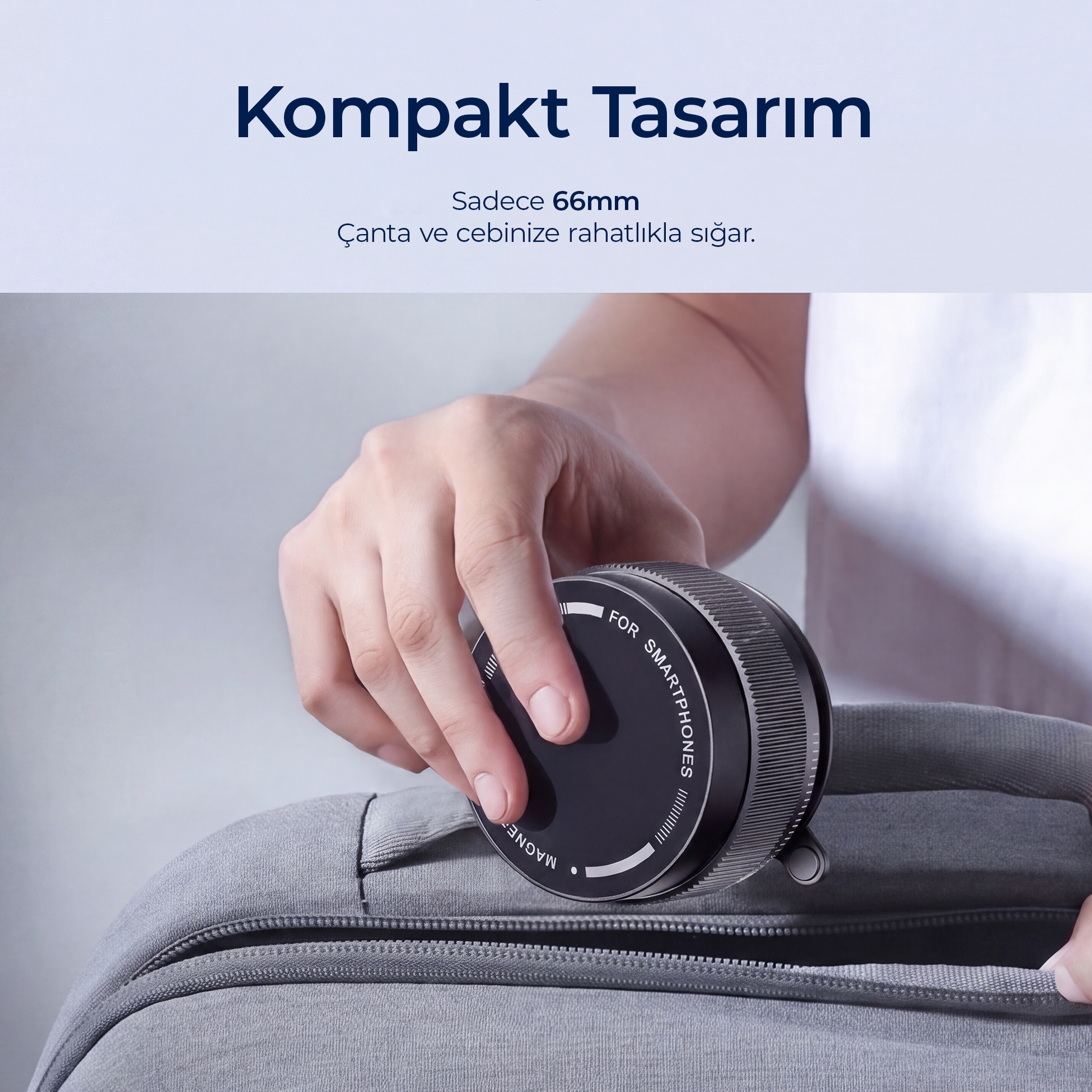 Bir kişi gri sırt çantası cebine kompakt 66 mm yuvarlak bir cihaz yerleştiriyor.