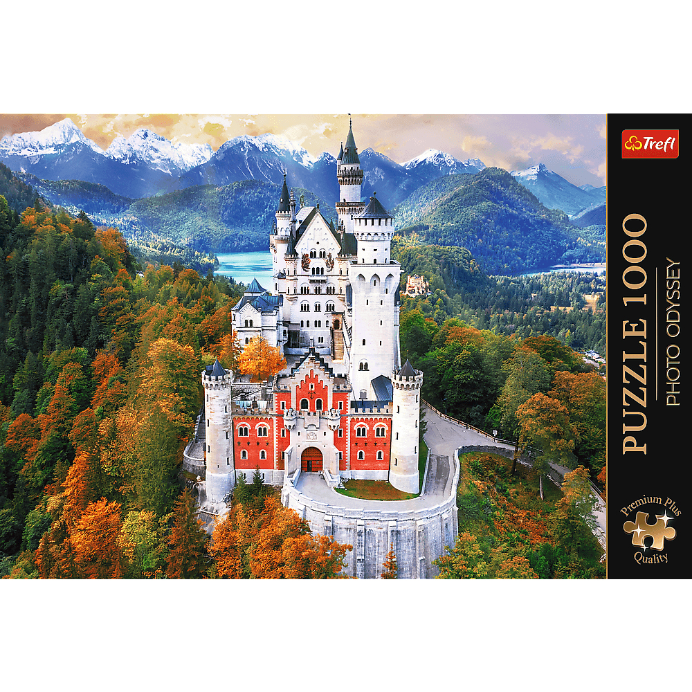 Neuschwanstein-Schloss umgeben von herbstlichen Wäldern und schneebedeckten Bergen.