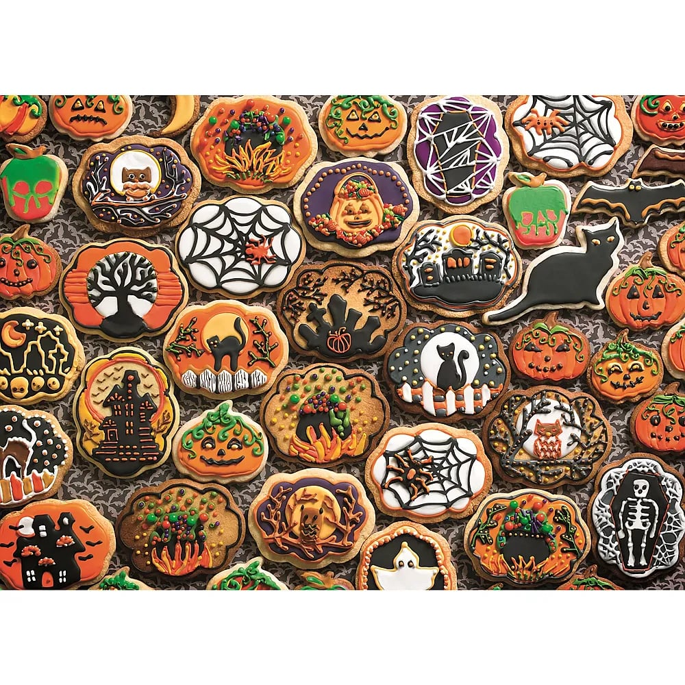 Eine Auswahl an dekorierten Halloween-Keksen mit Kürbissen, Katzen, Netzen und Spukhäusern vor dunklem Hintergrund.