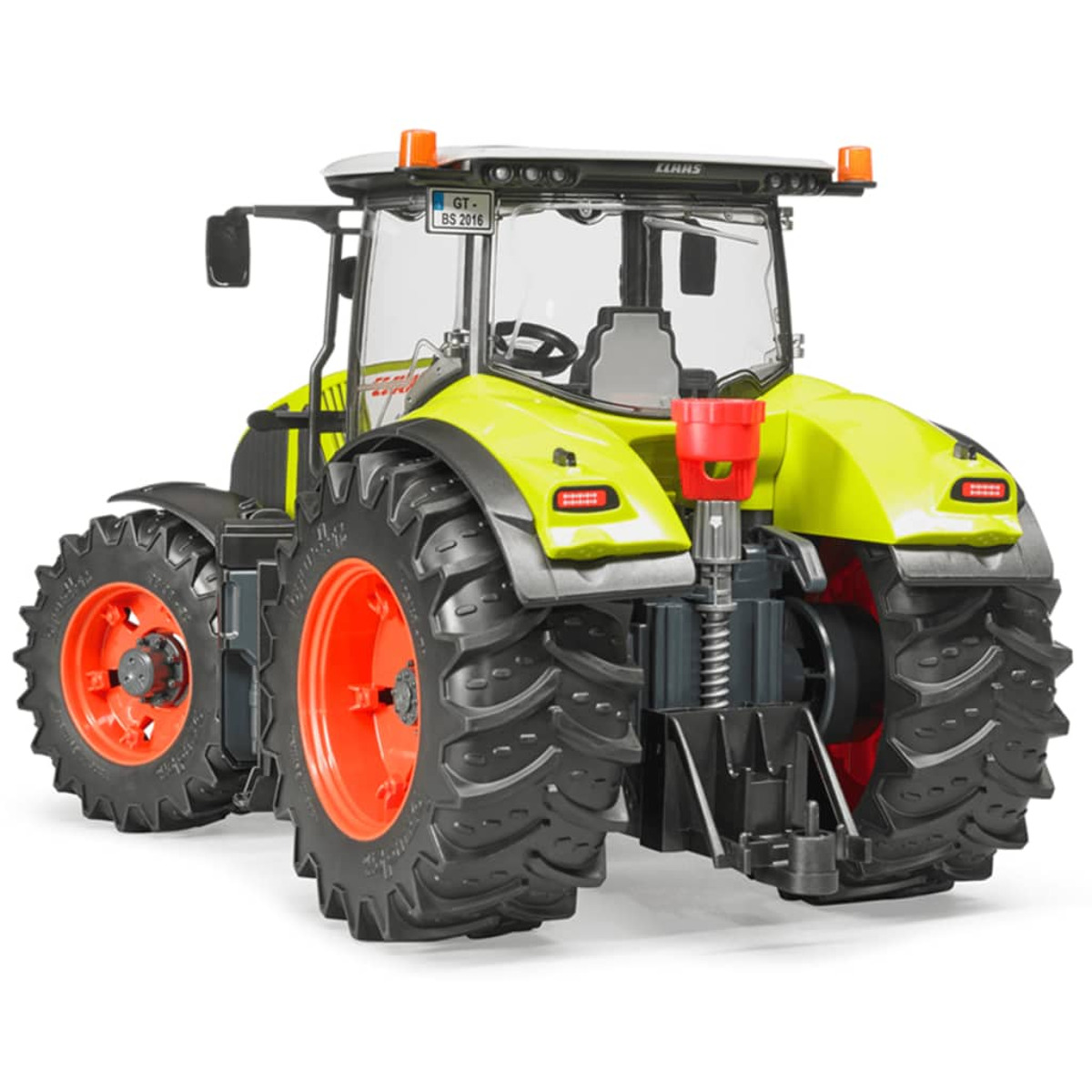 Ein detailliertes Modell eines gelb-grünen Claas-Traktors mit großen schwarzen Reifen und roten Felgen auf weißem Grund.