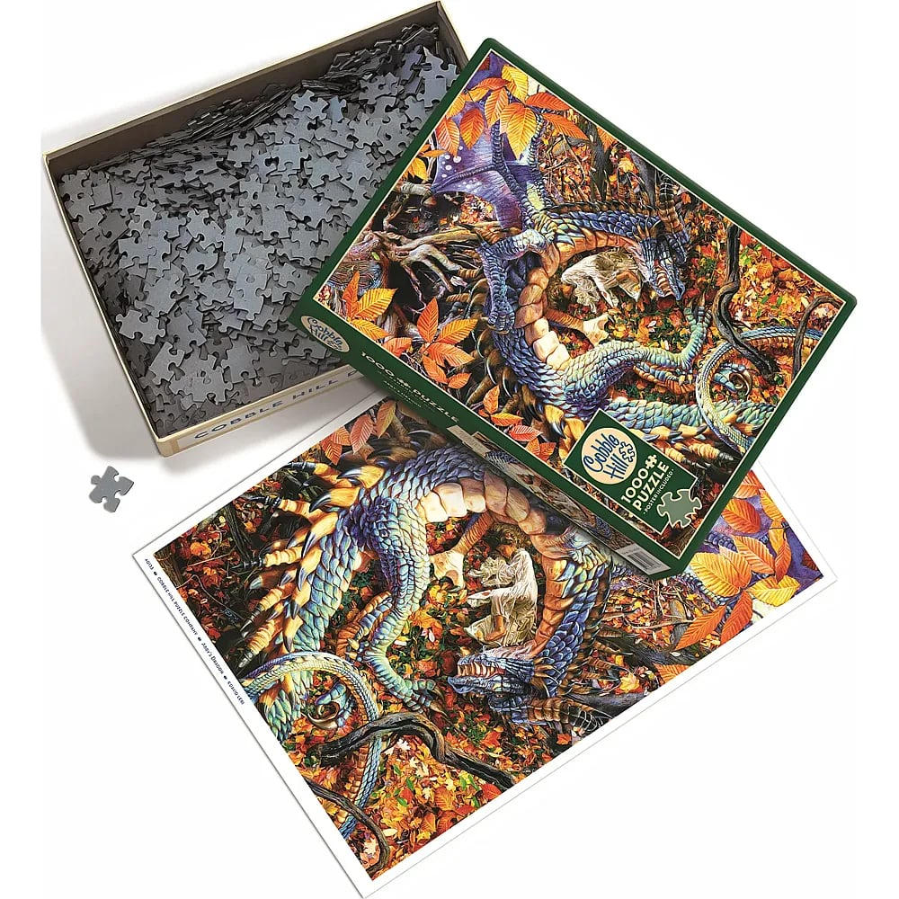 Ein Cobble Hill 1000-Teile-Puzzle mit einem Drachen im Herbstlaub, offener Schachtel voller Teile und Poster.