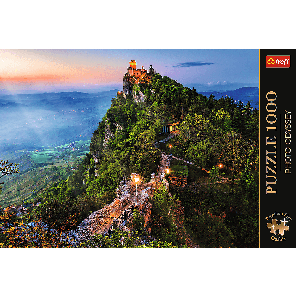 Eine beleuchtete Burg auf einem bewaldeten Berg im Abendlicht, mit Blick auf ein weitläufiges Tal und Puzzle-Rand.