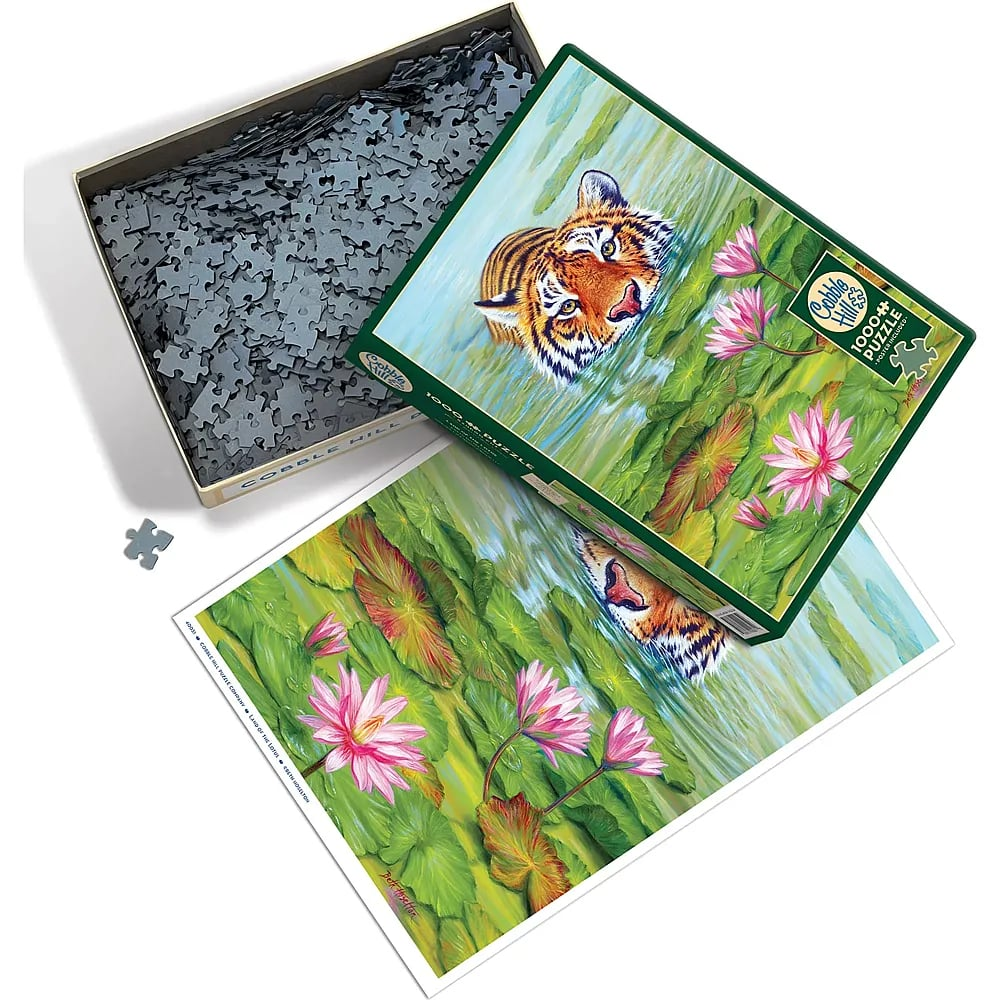 Eine Tiger-Puzzleschachtel mit losen Teilen und Poster mit Tiger im Wasser und Seerosen.