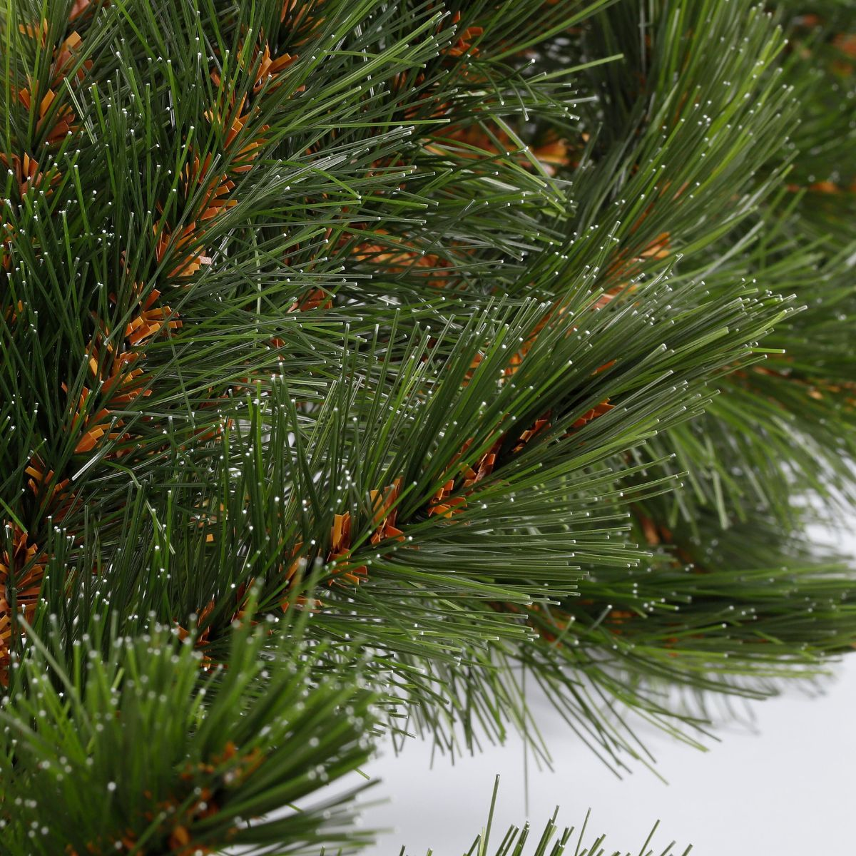 Branches de pin vertes denses avec des accents marron.