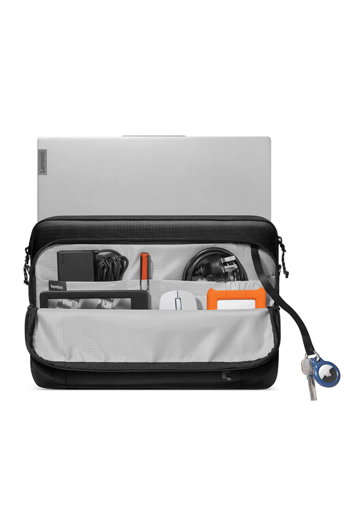 Beyaz arka planda açık siyah laptop çantasında laptop, şarj aleti, fare, kablolar, kalem ve anahtarlar var.