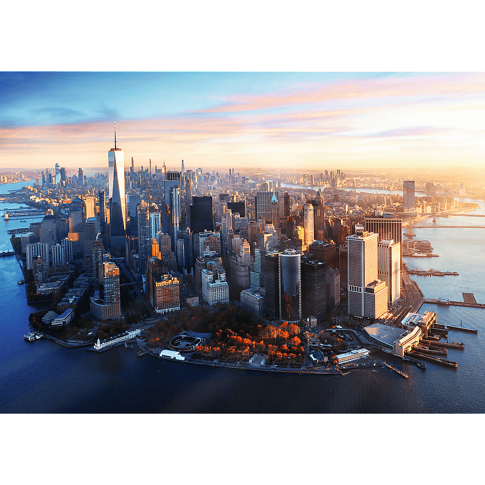 Luftaufnahme der Skyline von New York City bei Sonnenuntergang mit Wolkenkratzern, Flüssen und orange leuchtenden Bäumen.
