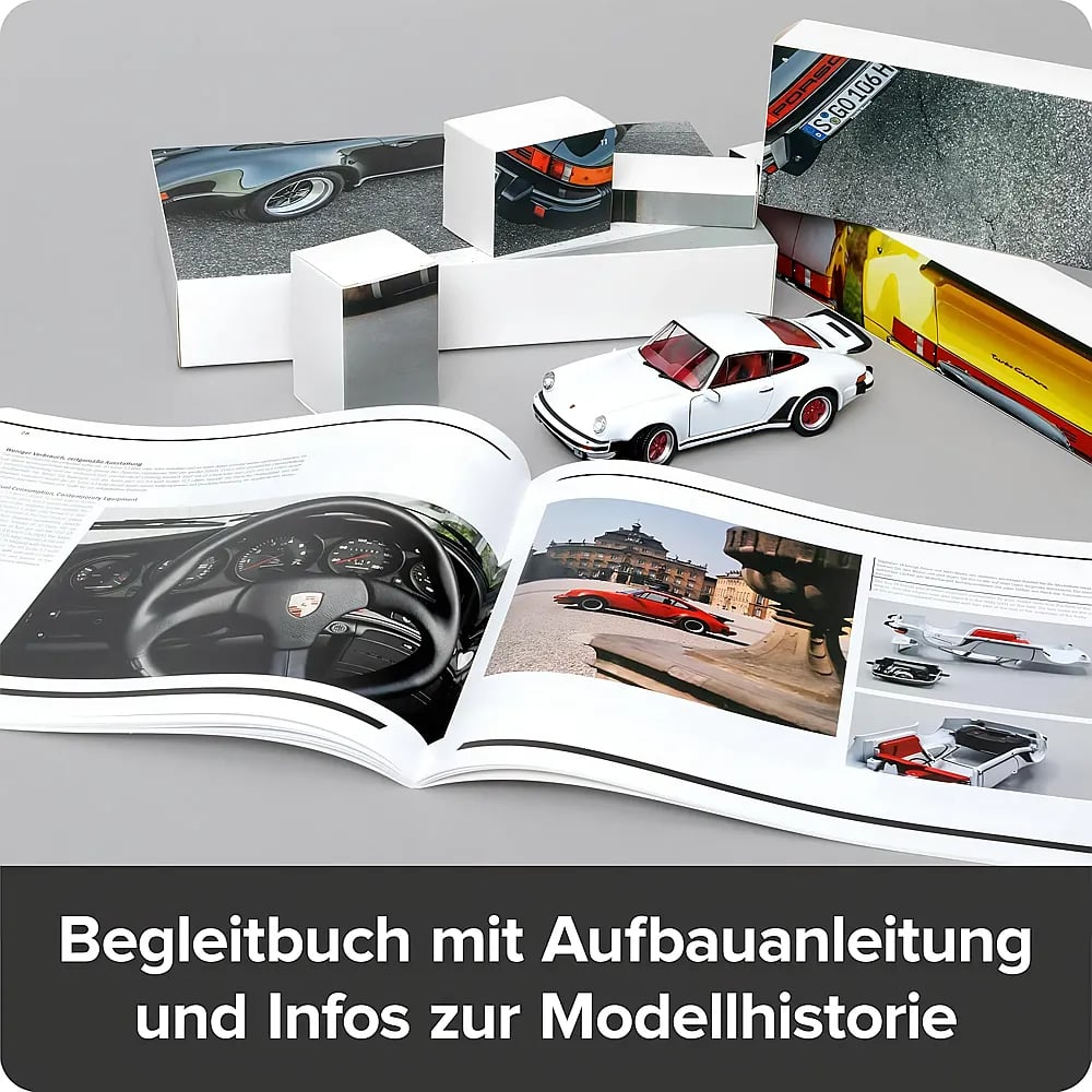 Ein offenes Buch zeigt Autofotos und eine Anleitung, neben einem weißen Modellauto und Schachteln.
