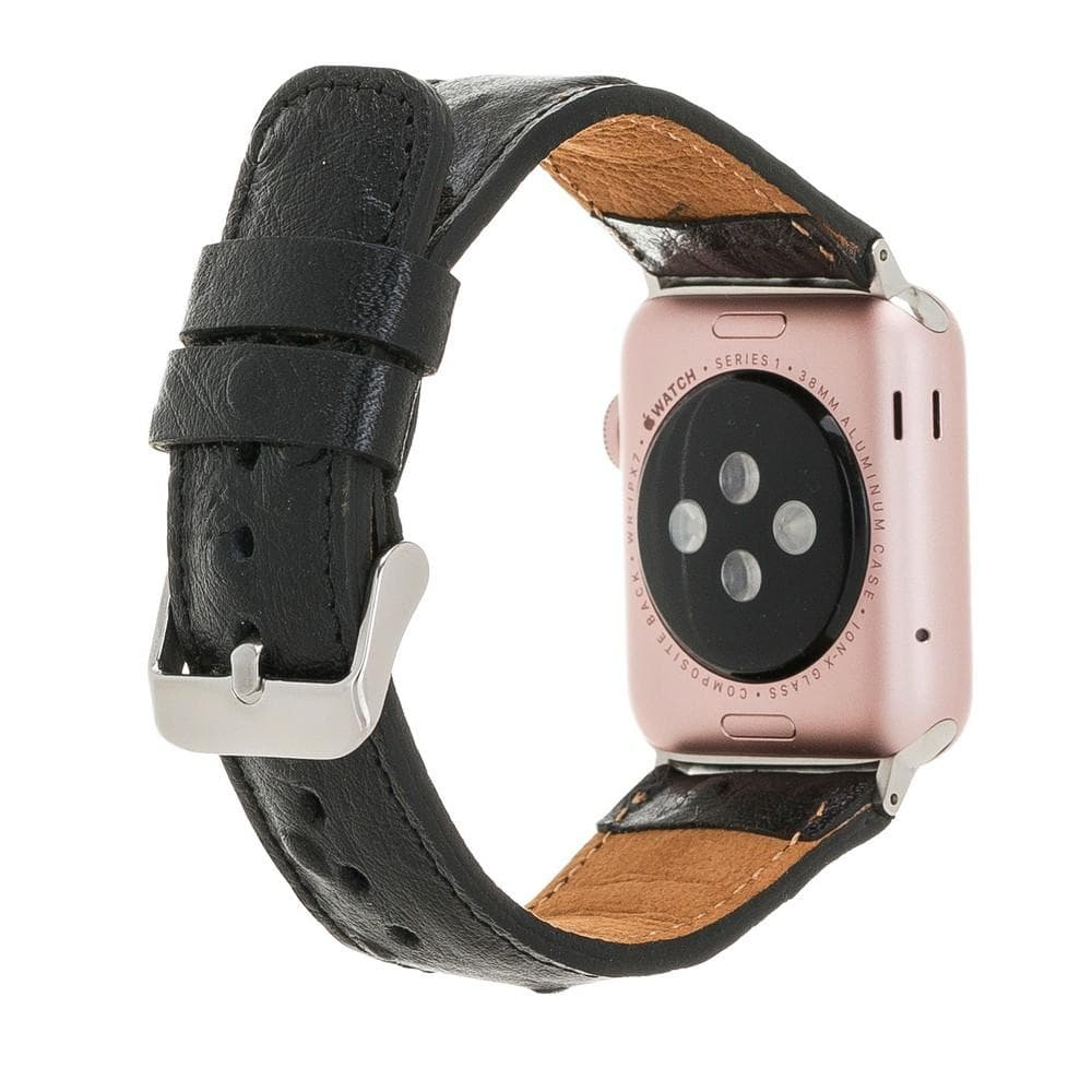 Beyaz arka planda siyah deri kayışlı ve gümüş tokalı pembe altın renkli bir Apple Watch'un arkası.