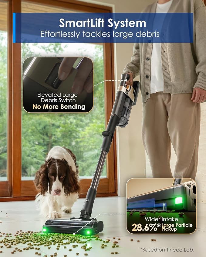 Une personne utilise un aspirateur SmartLift pour nettoyer des croquettes sur le sol pendant qu'un chien regarde.