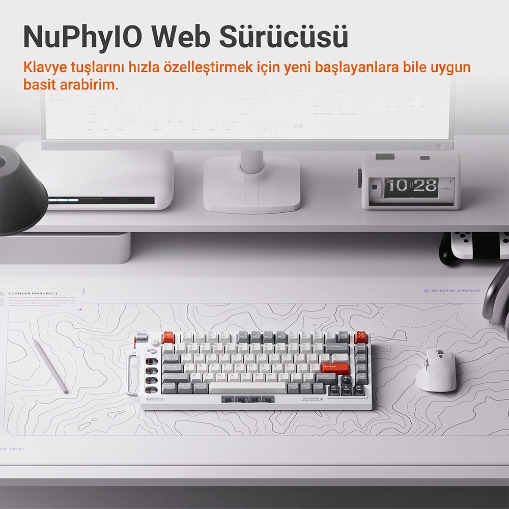 Biała klawiatura mechaniczna i mysz leżą na podkładce pod biurko pod monitorem i zegarem.