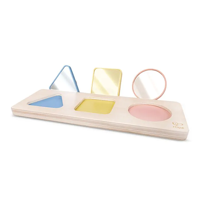 Un juguete de rompecabezas Montessori de madera con tres formas coloridas y reflectantes: un triángulo azul, un cuadrado amarillo y un círculo rosa.