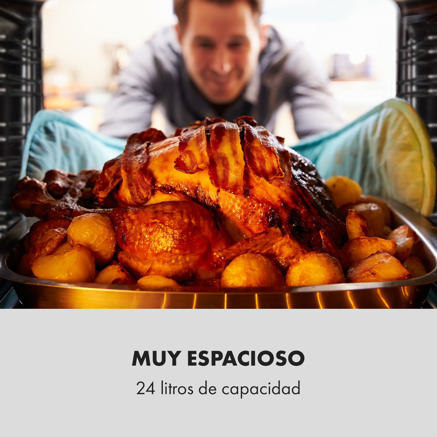 Un hombre sonríe mientras saca del horno un pavo asado con beicon y patatas.
