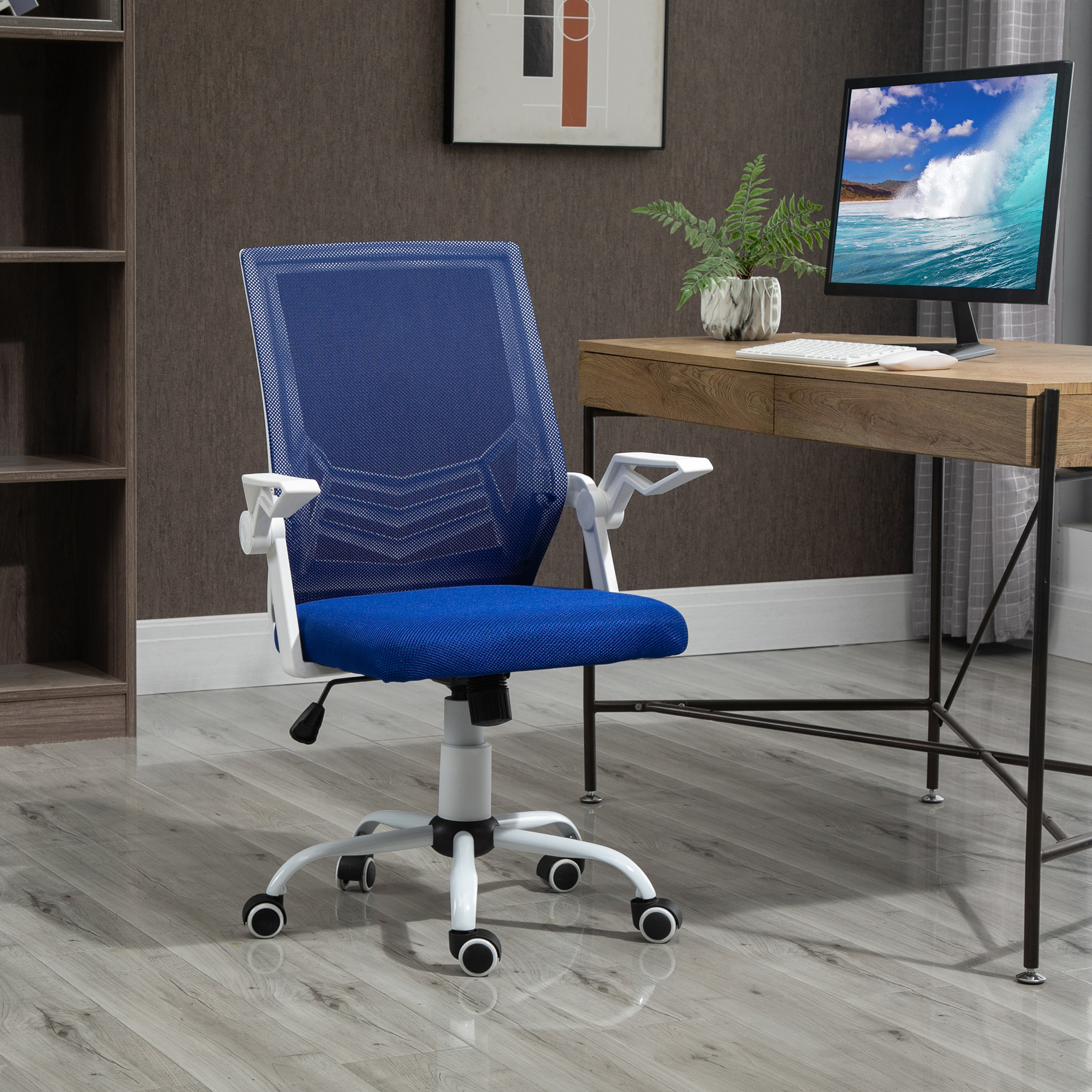 Una sedia da ufficio blu con struttura bianca su pavimento in legno grigio davanti a una scrivania con computer.