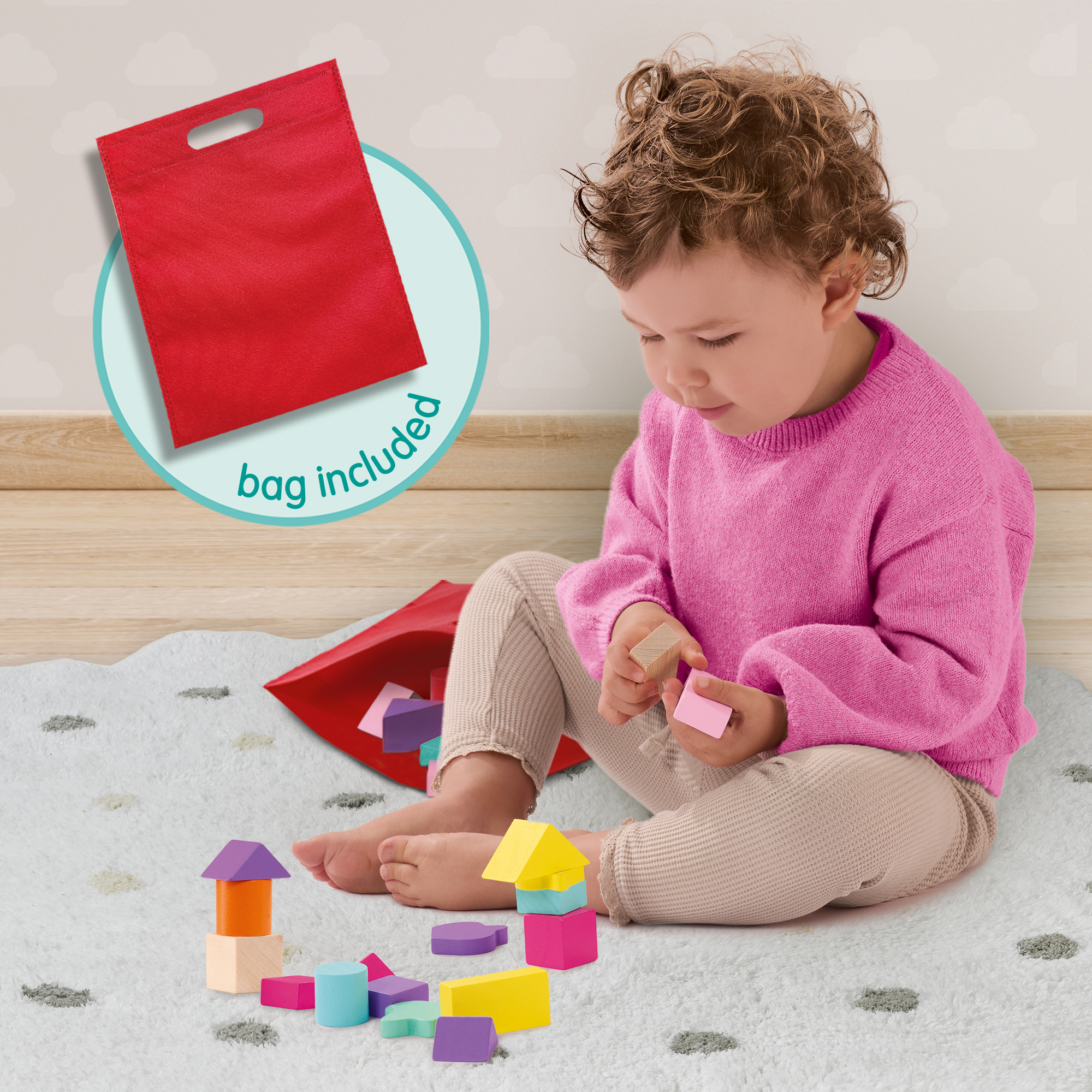 Kleinkind in pinkem Pullover sitzt auf einem Teppich und spielt mit bunten Bauklötzen.