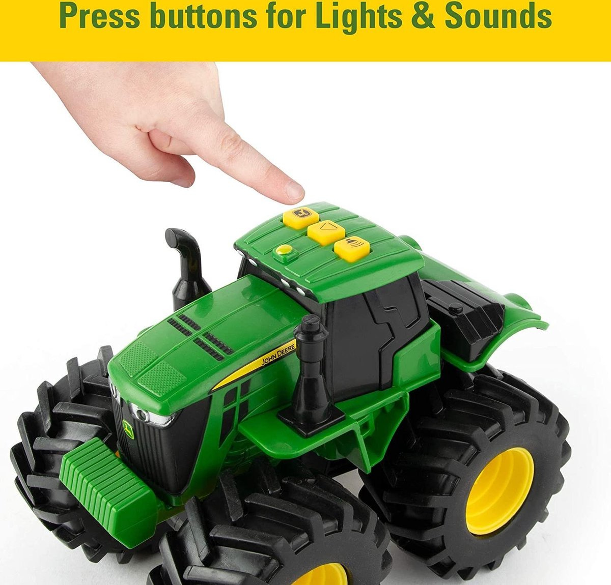 Une main appuie sur des boutons jaunes sur un tracteur jouet vert.