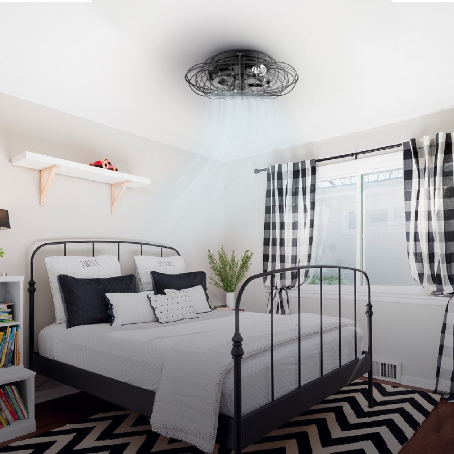 Schlafzimmer mit schwarzem Metallbett, schwarz-weiß karierten Vorhängen und einem Ventilator an der Decke.