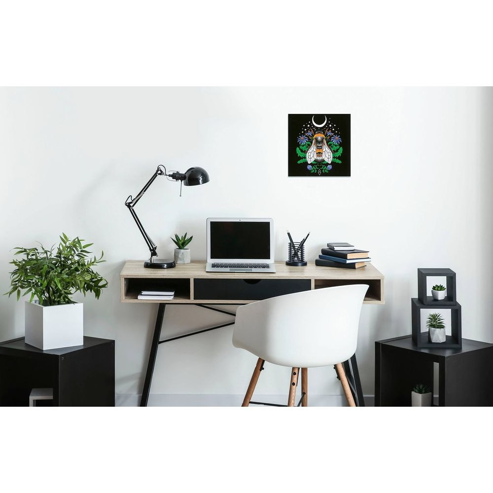 Ein minimalistischer Arbeitsbereich mit Holztisch, Laptop, schwarzer Lampe und dekorativen Pflanzen.