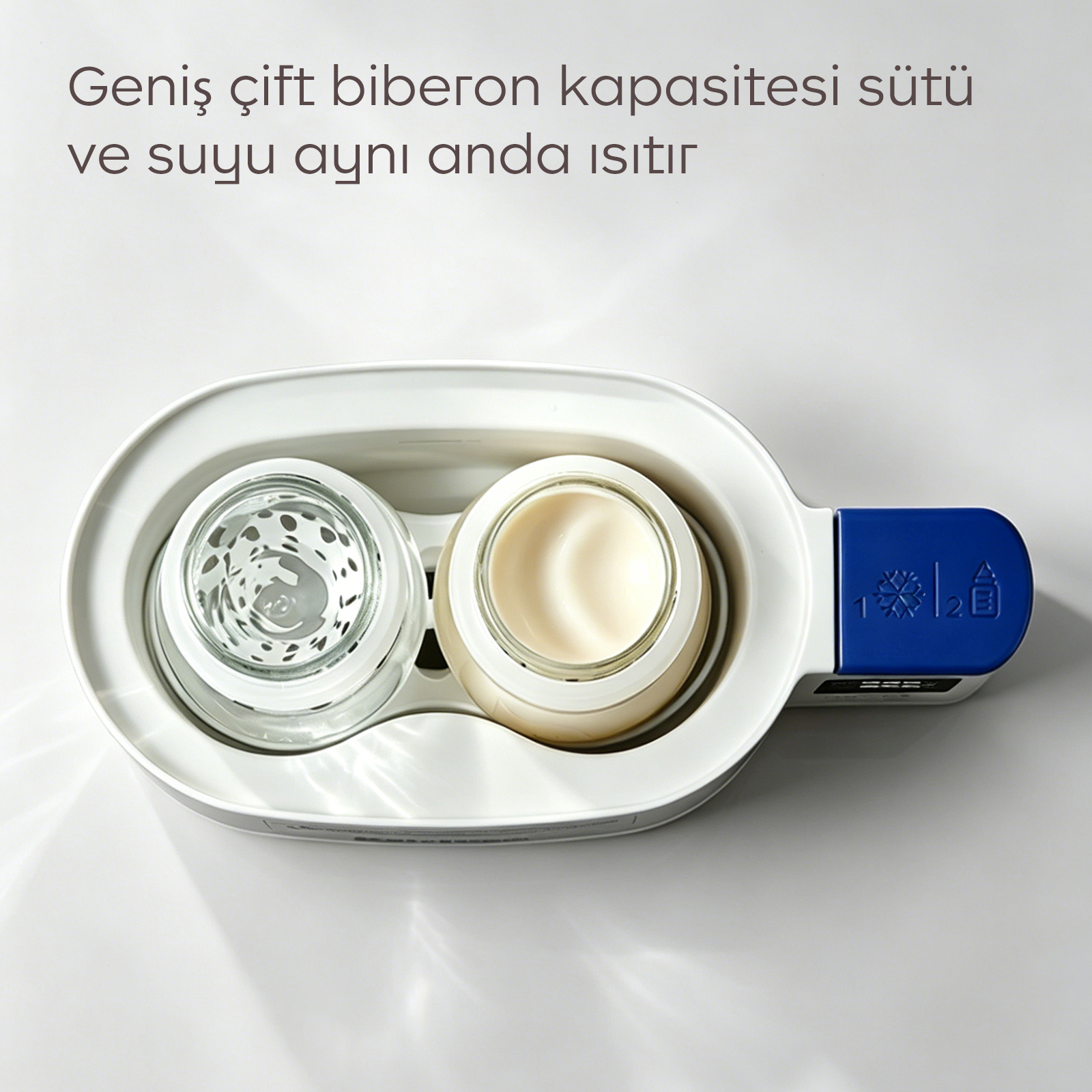 Süt ve suyu aynı anda ısıtan, iki kavanoz ve mavi kontrollere sahip beyaz çiftli biberon ısıtıcısı.