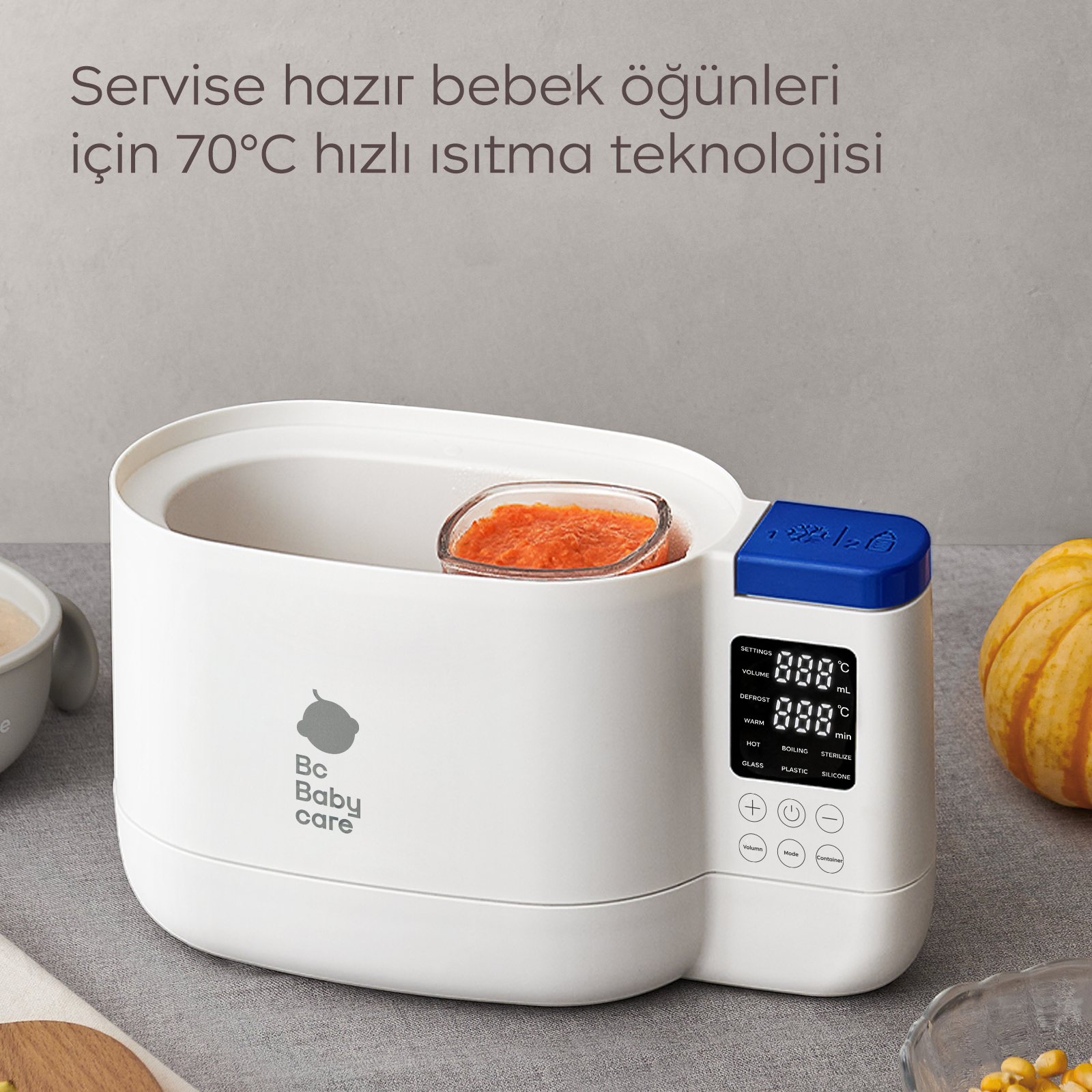 Gri zemin üzerinde dijital ekranlı ve içinde turuncu mama olan beyaz Bc Baby Care mama ısıtıcısı.