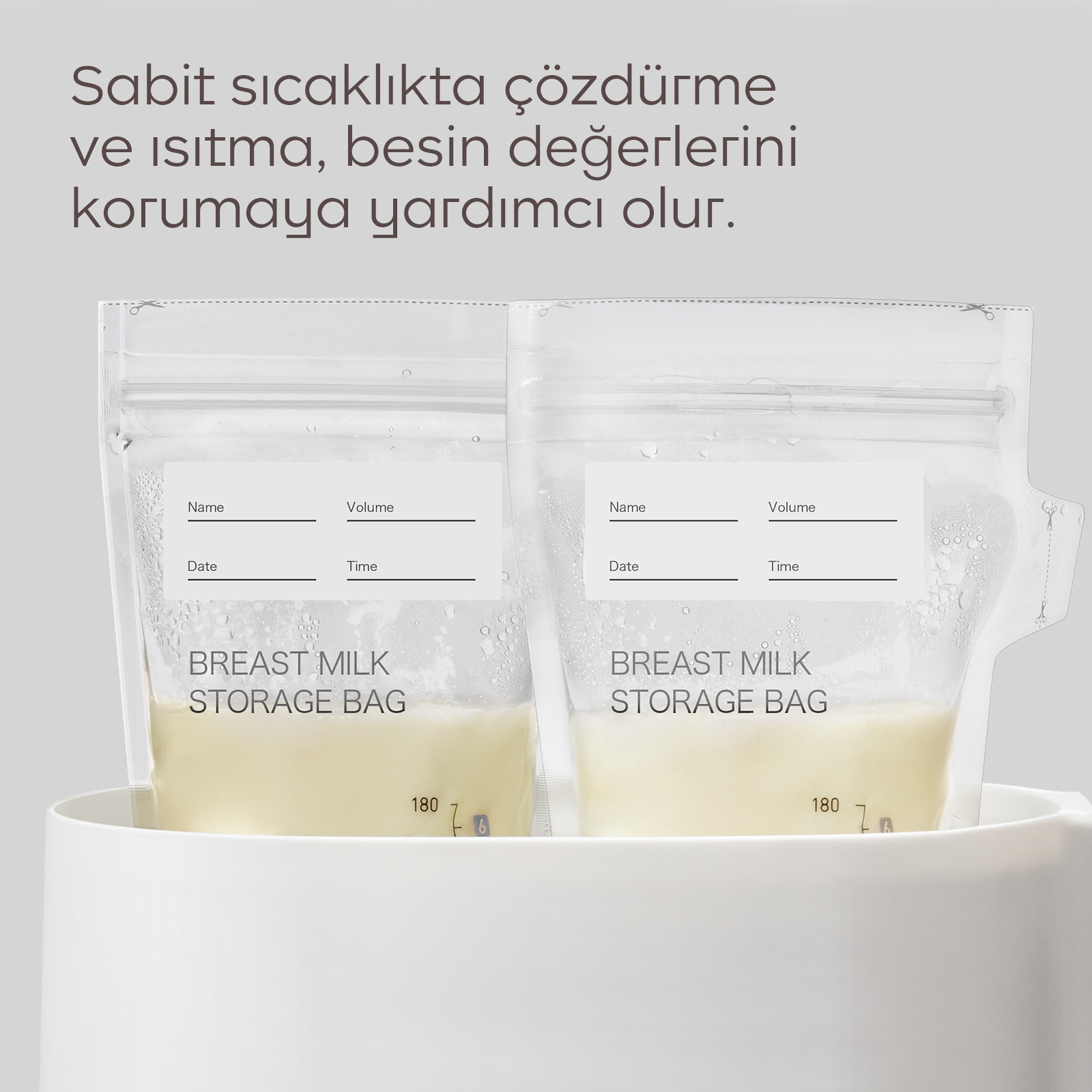 Beyaz bir kap içinde sıvı dolu iki anne sütü saklama poşeti, üzerinde Türkçe yazı var.