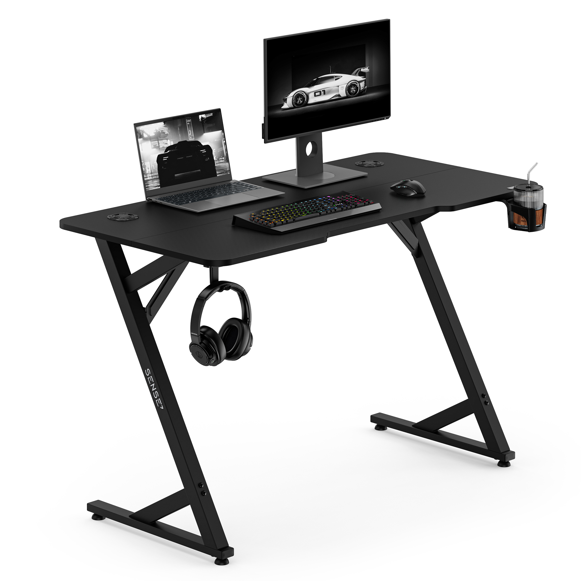 Ein schwarzer Gaming-Tisch mit Laptop, Monitor, RGB-Tastatur, Maus, Kopfhörern und Getränkehalter.