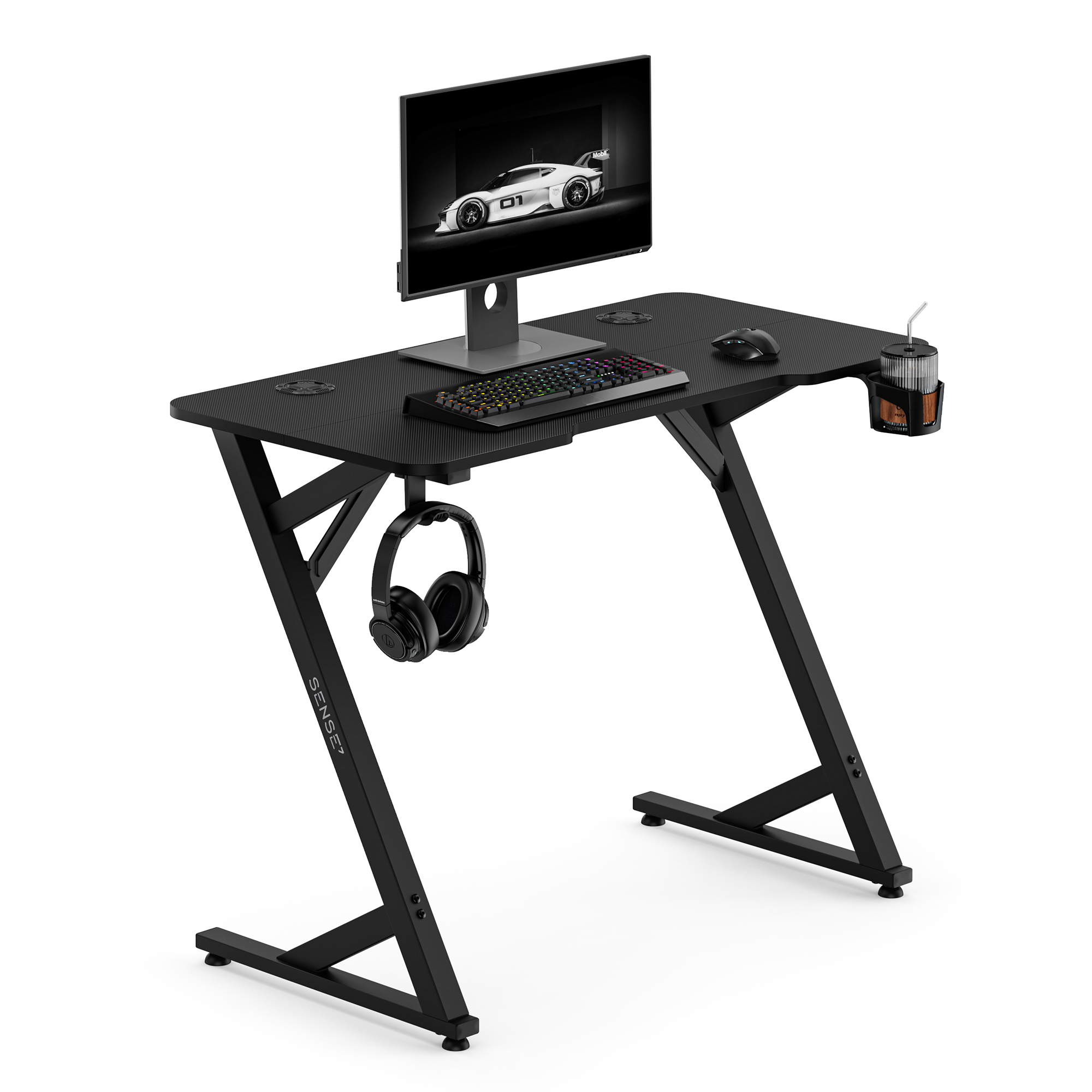 Black gaming desk featuring a monitor, RGB keyboard, mouse, hanging headphones, and a cup holder.