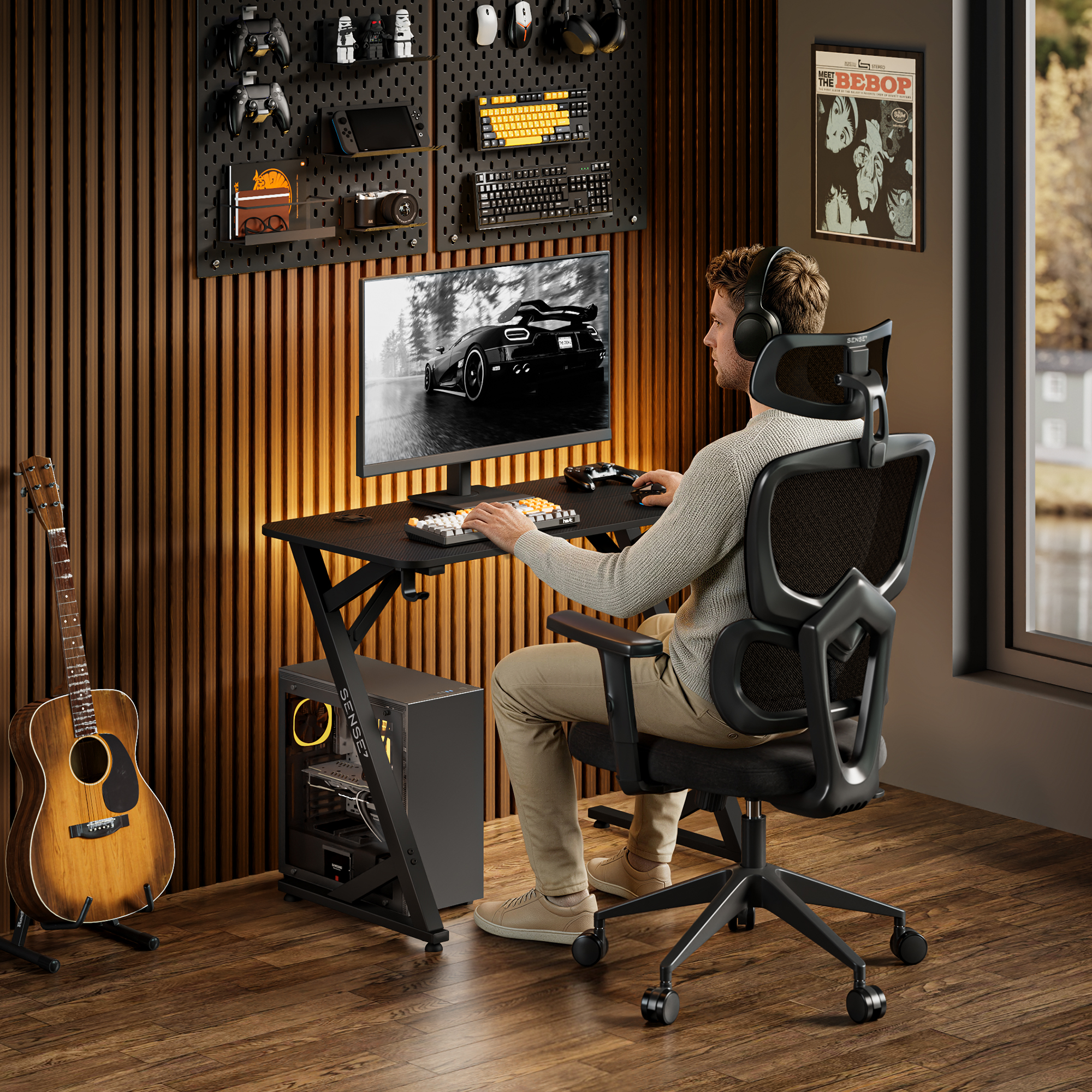 A young man sits in a modern gaming chair at a desk, playing a racing game on his computer.