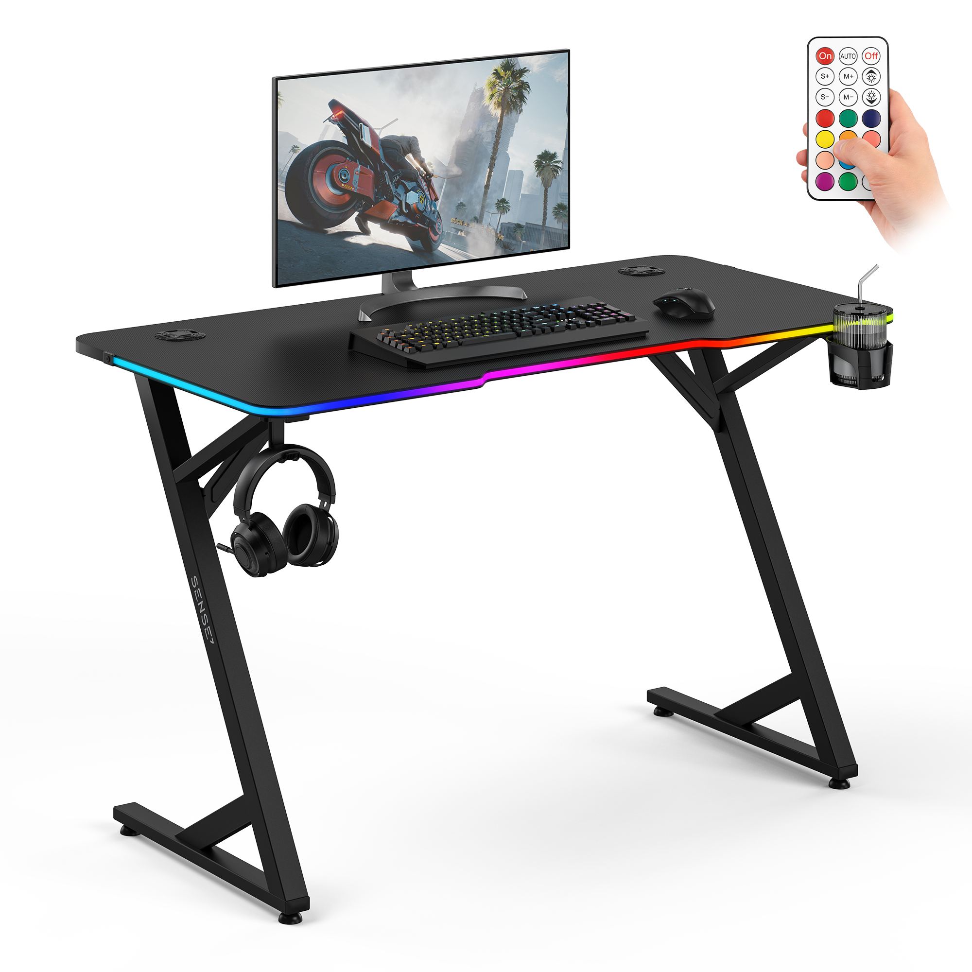 Schwarzer Gaming-Schreibtisch mit RGB-Beleuchtung, Monitor, Tastatur, Maus, Kopfhörern und Fernbedienung.