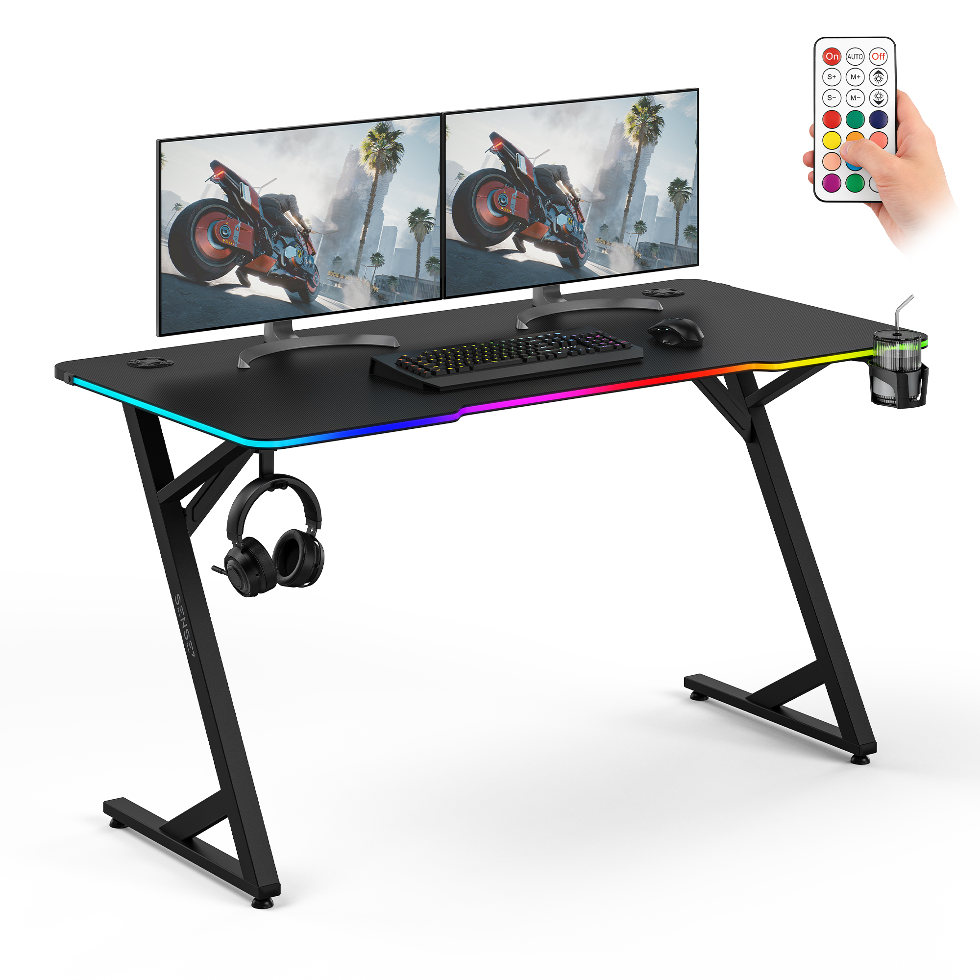Ein schwarzer Gaming-Schreibtisch mit zwei Monitoren, Tastatur, Kopfhörern, Getränkehalter und RGB-Beleuchtung.