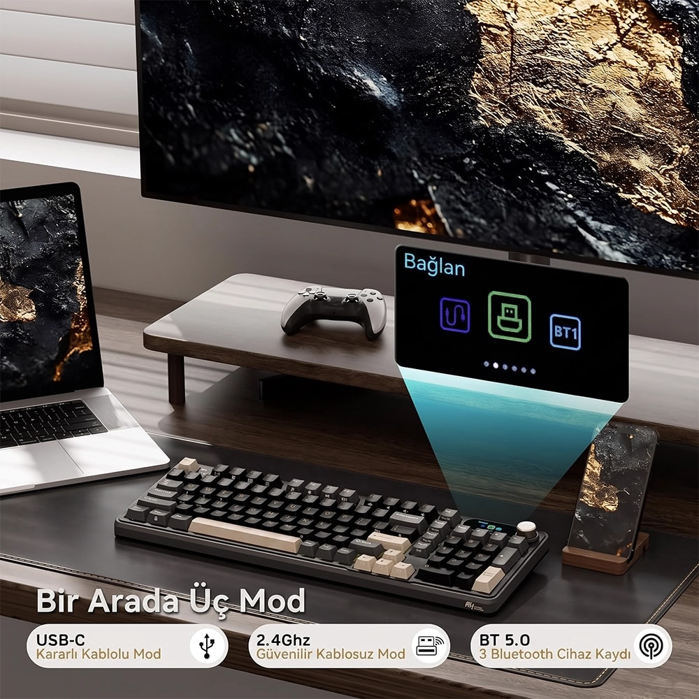 Klavye, dizüstü bilgisayar, monitör ve üç bağlantı modu gösteren telefonun bulunduğu bir masa: USB-C, 2.4GHz ve BT 5.0.