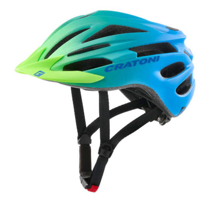 Ein blau-grüner Cratoni Fahrradhelm mit schwarzen Riemen vor weißem Hintergrund.