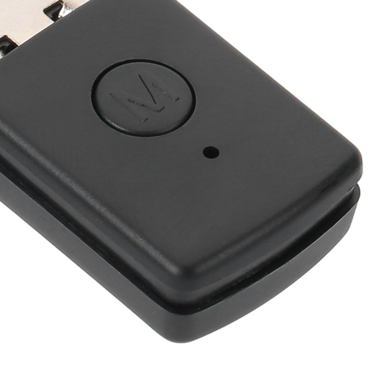 Ein kleiner schwarzer USB-Stecker mit einer runden M-Taste und einem kleinen Loch auf der Oberfläche.