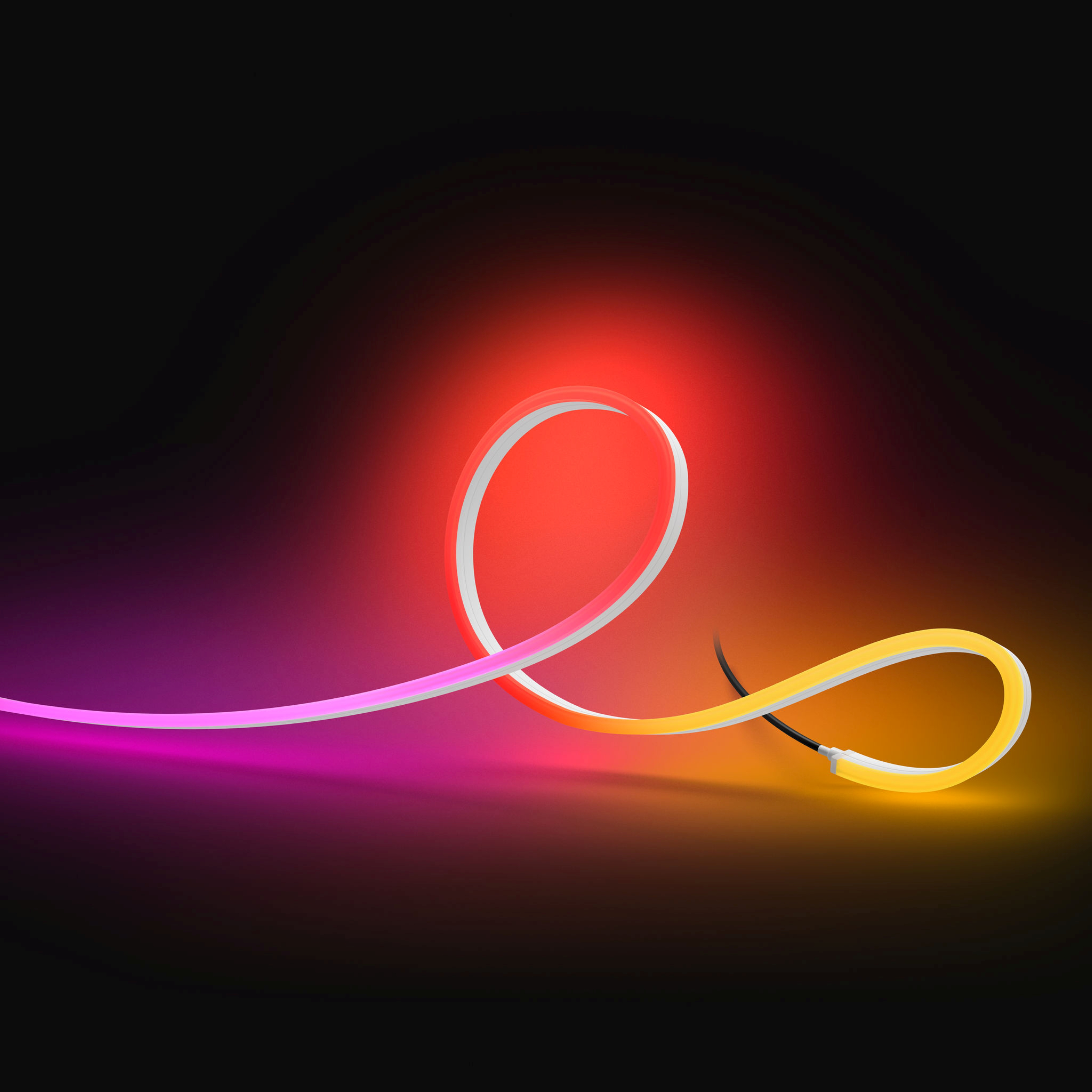 Una striscia LED flessibile si illumina con colori vivaci su sfondo scuro.